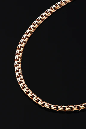 A close-up of a gold chain on black background