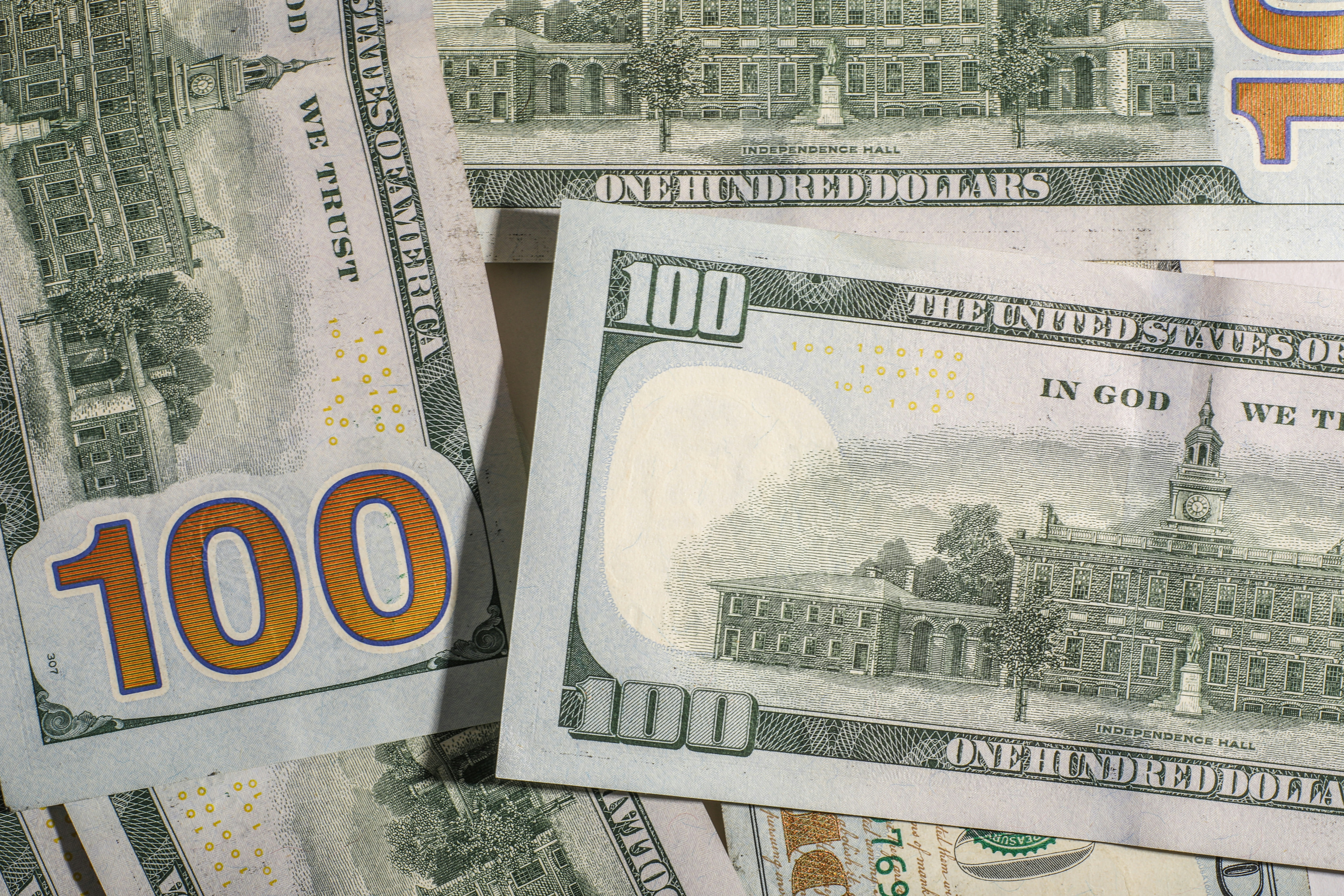 One hundred dollar bills are scattered.