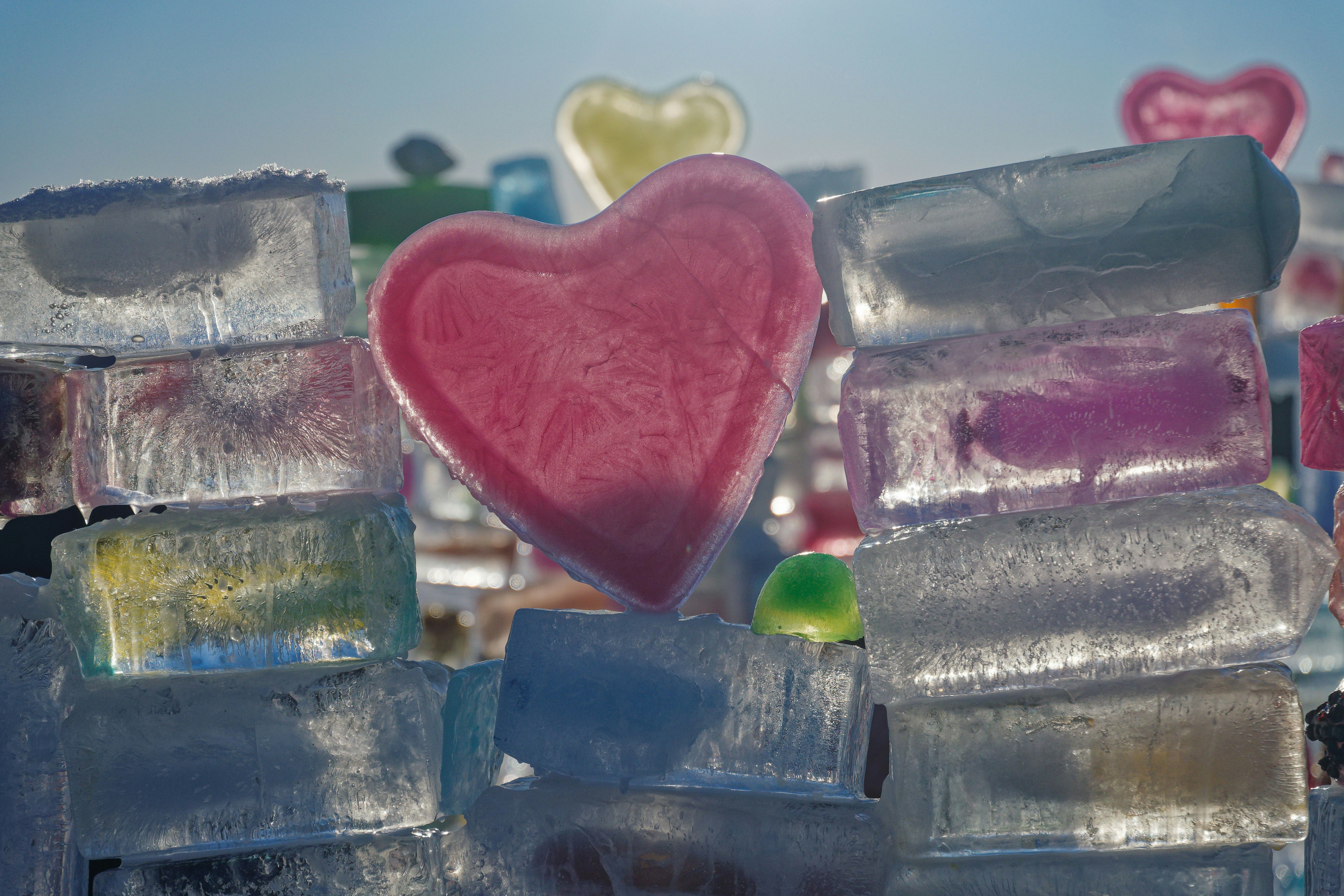 Pink heart shape made of ice with colorful ice blocks