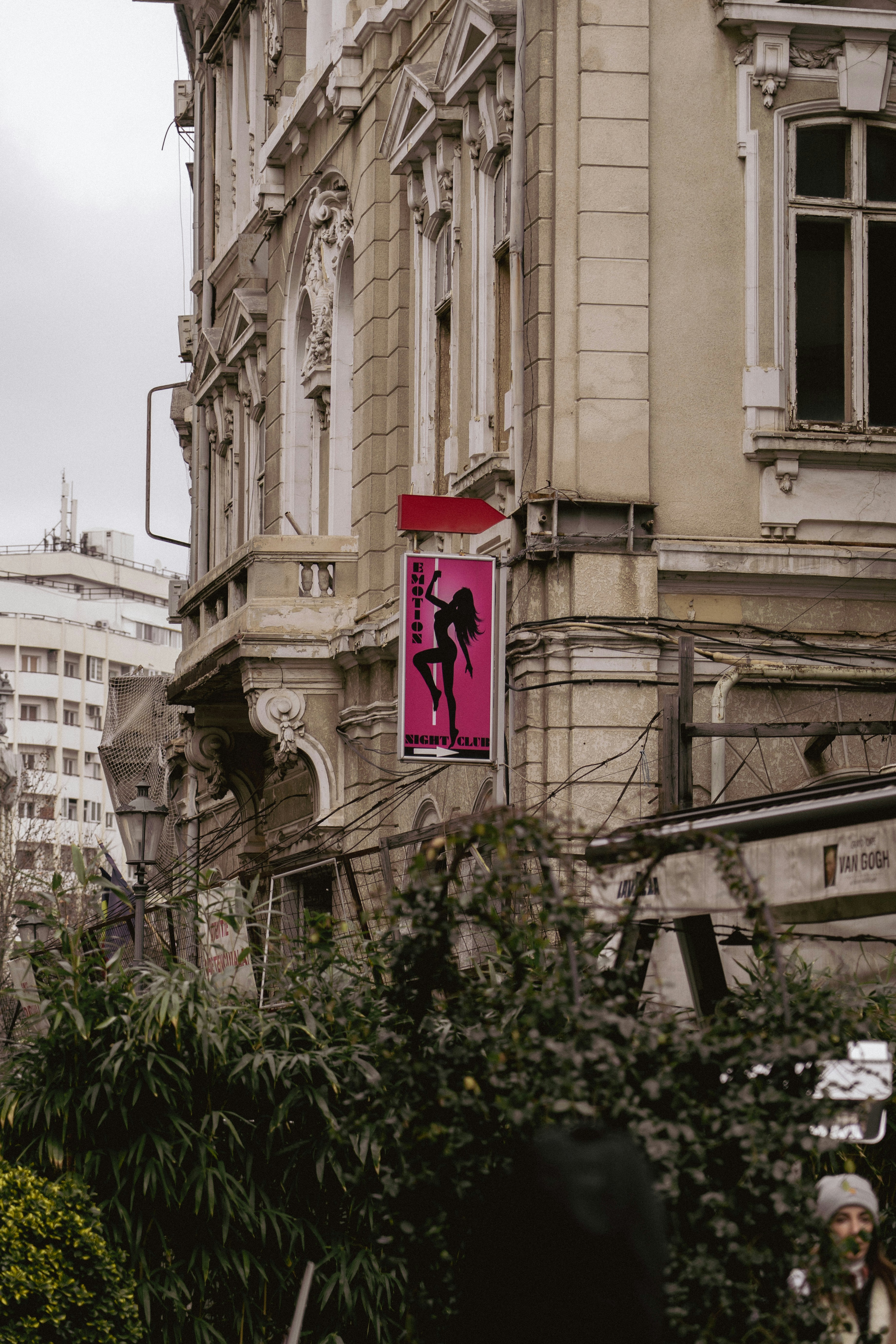 Pink sign with silhouette on old building