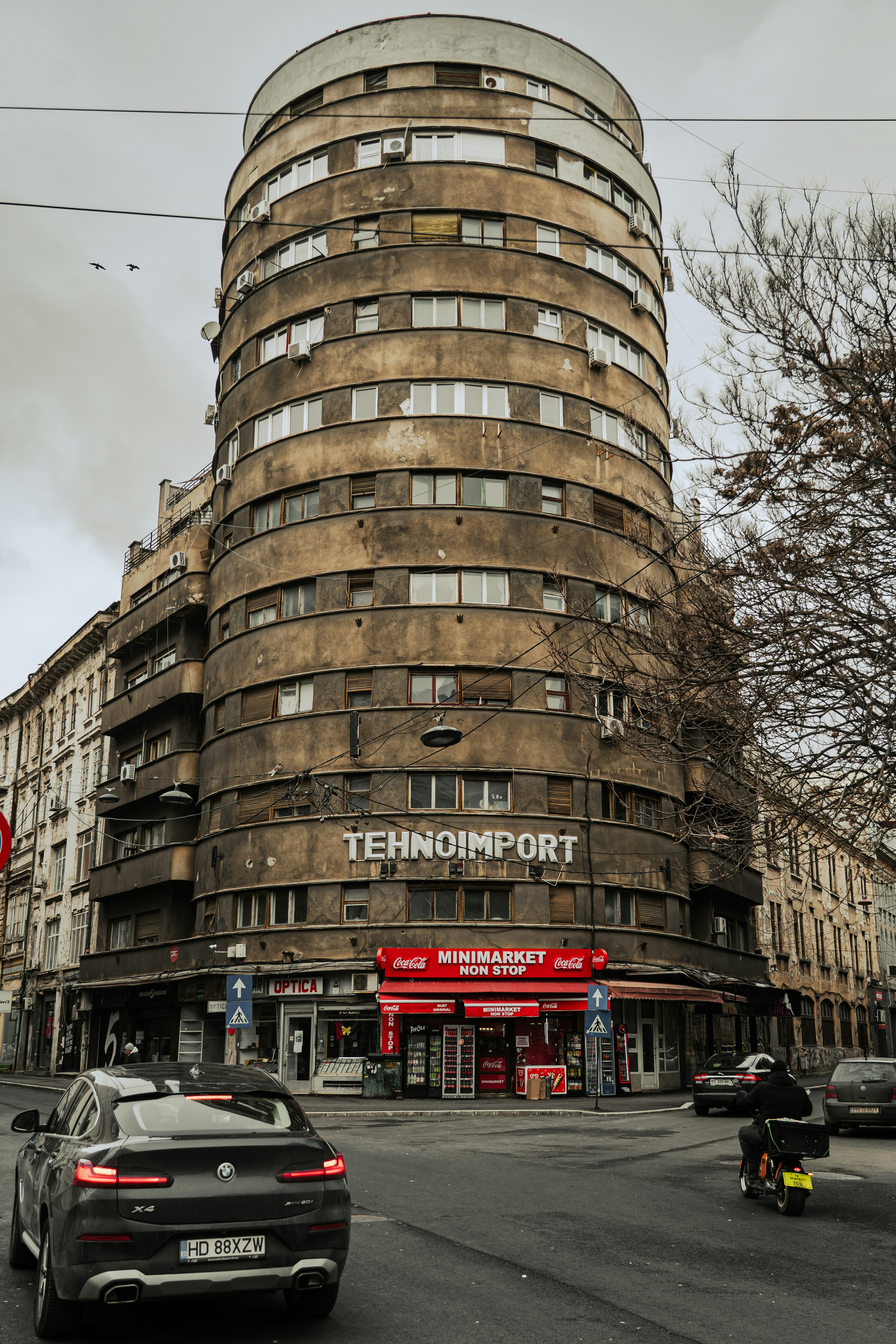 A brutalist apartment building with shops on ground floor.