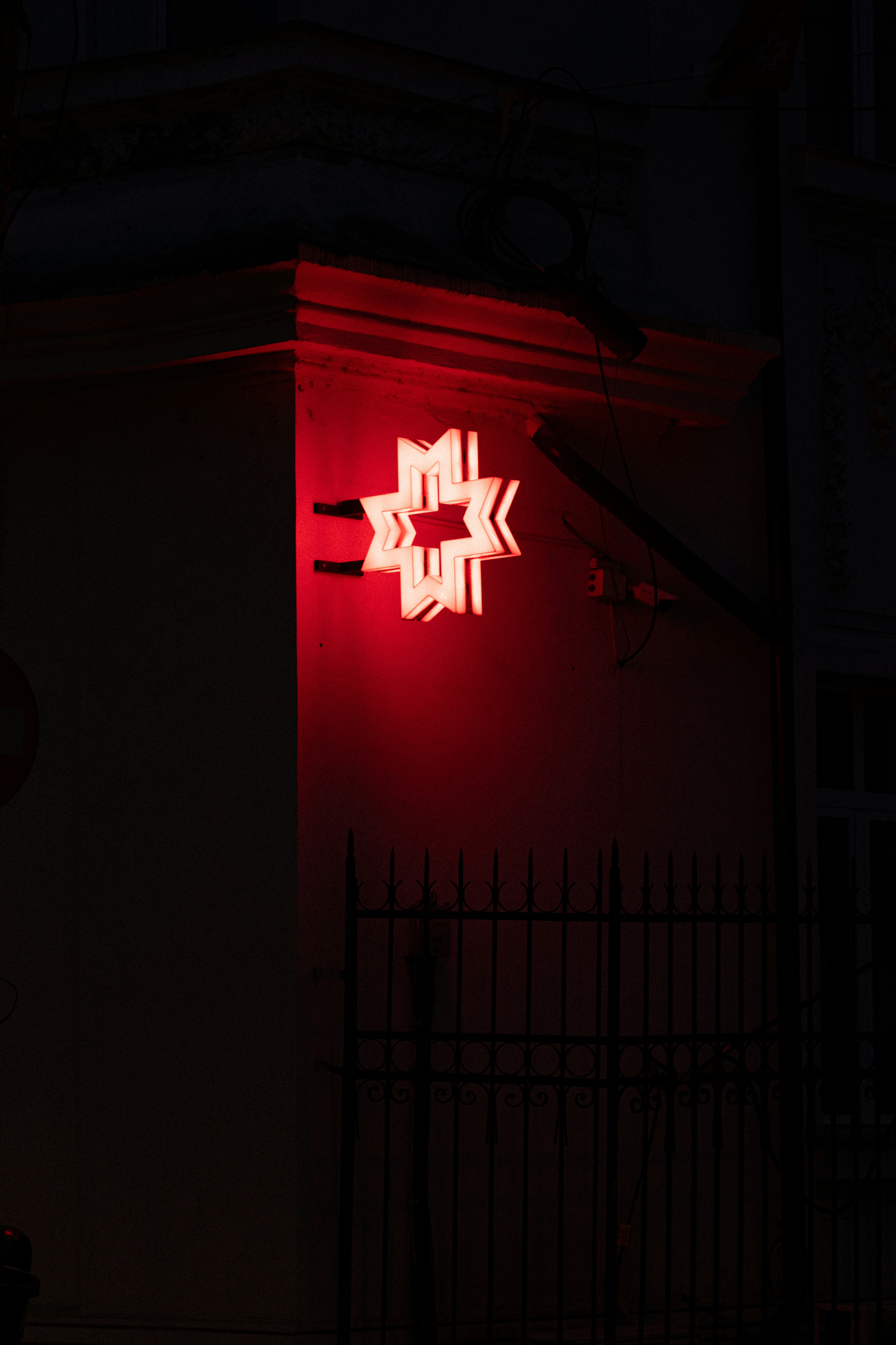 A bright red star-shaped sign glows at night.