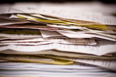 Unorganized stack of invoices and documents showing need for better billing and payment management