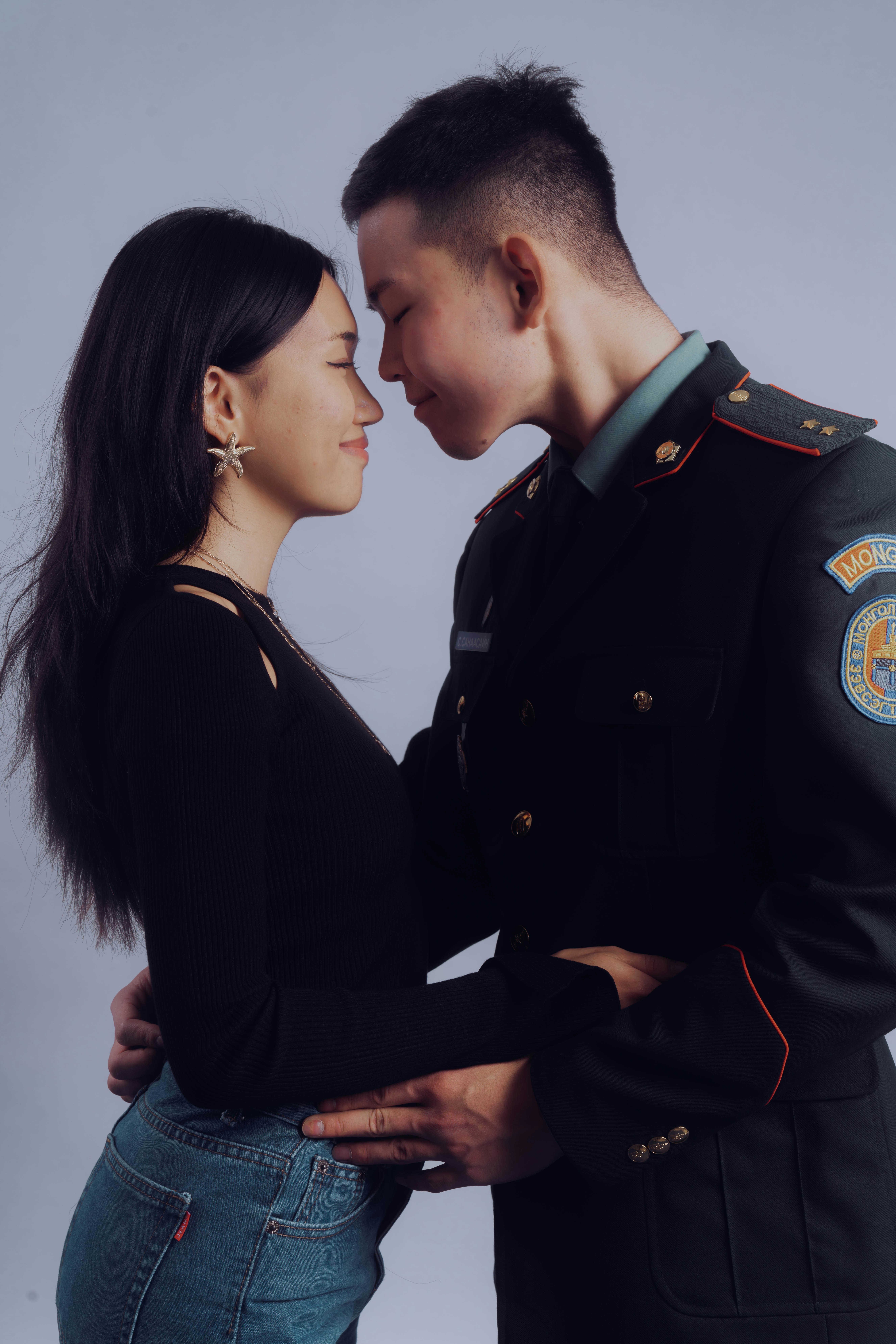 Couple in uniform embraces with eyes closed