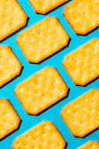 Rectangular crackers arranged diagonally on a bright blue background.