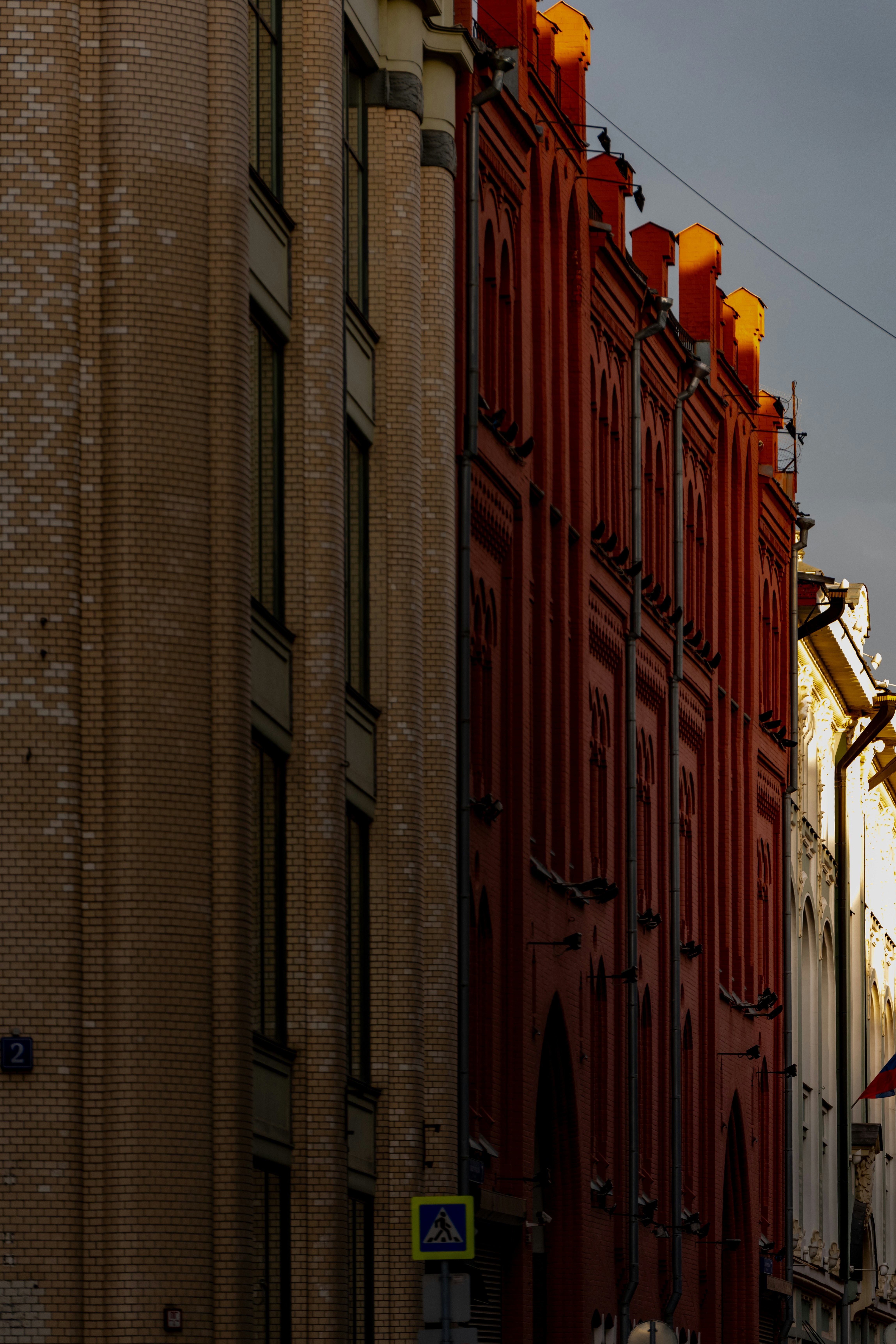 Edifício de tijolos vermelhos com janelas arqueadas e detalhes ornamentados.