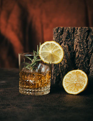 A whiskey cocktail with lemon and rosemary garnish