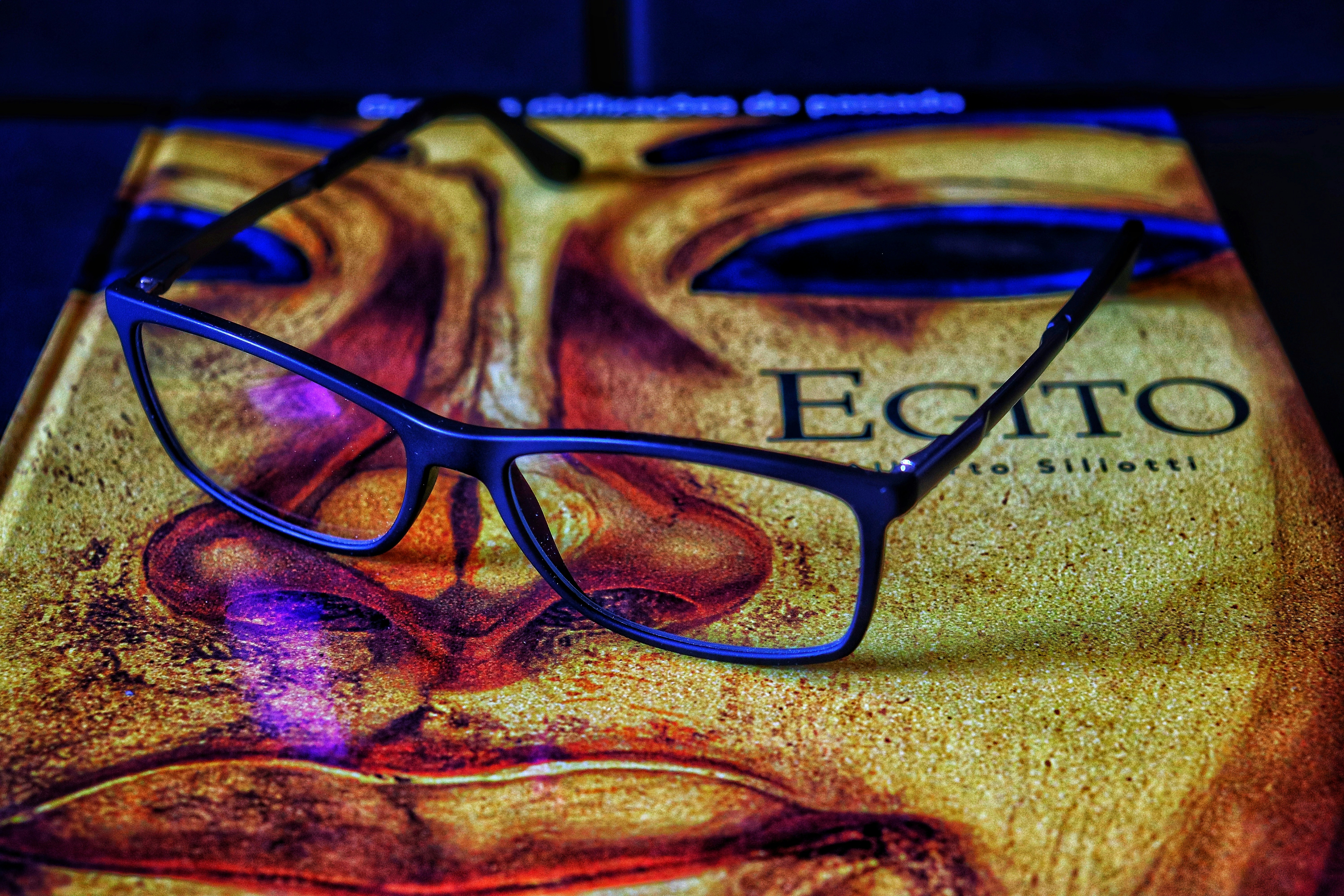 Eyeglasses resting on an artistic book cover.