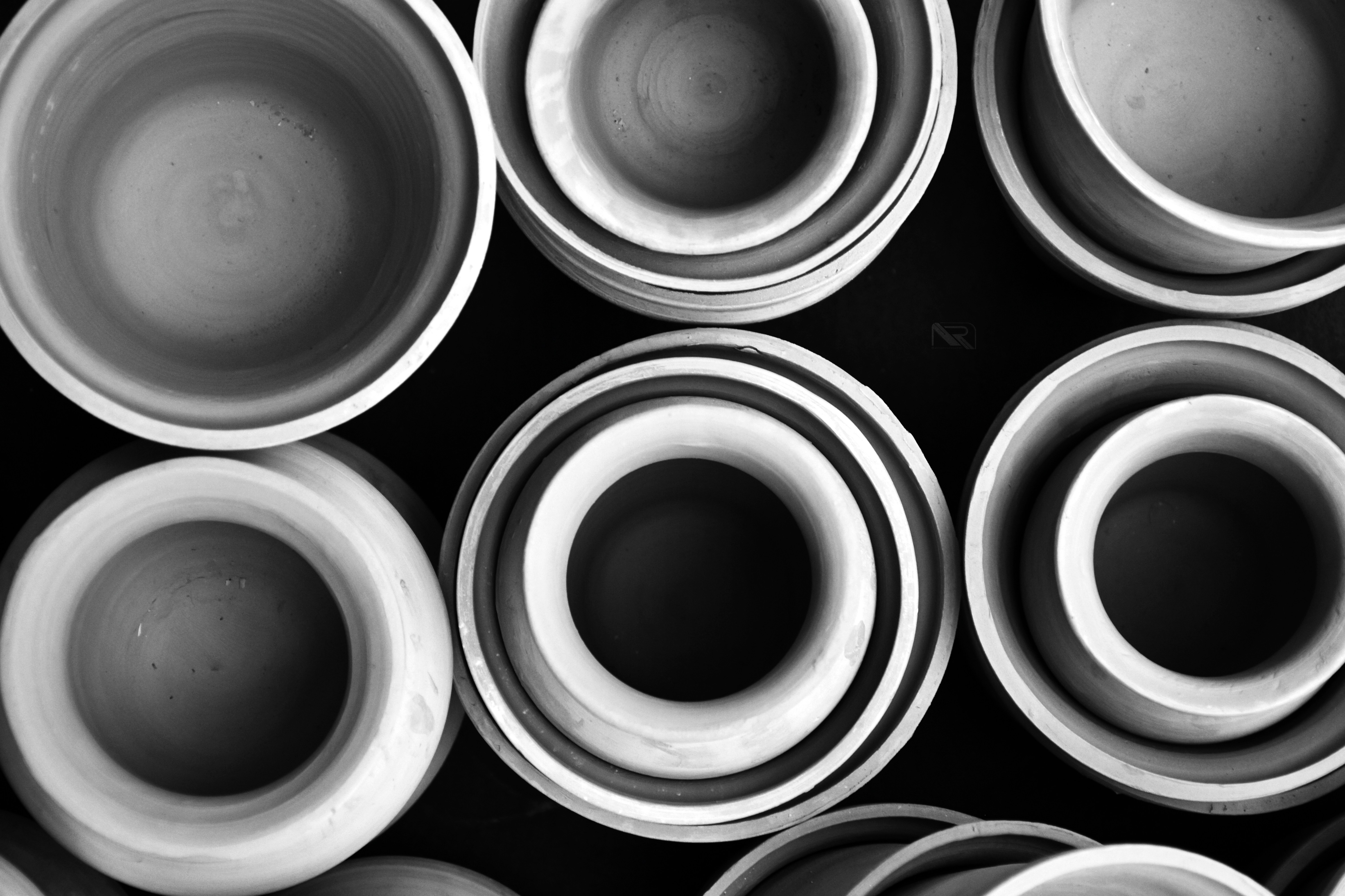 Several ceramic bowls stacked on a dark surface