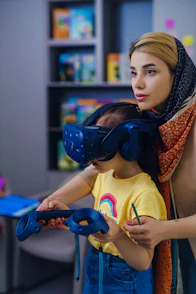 Woman helps child use virtual reality headset and controllers.