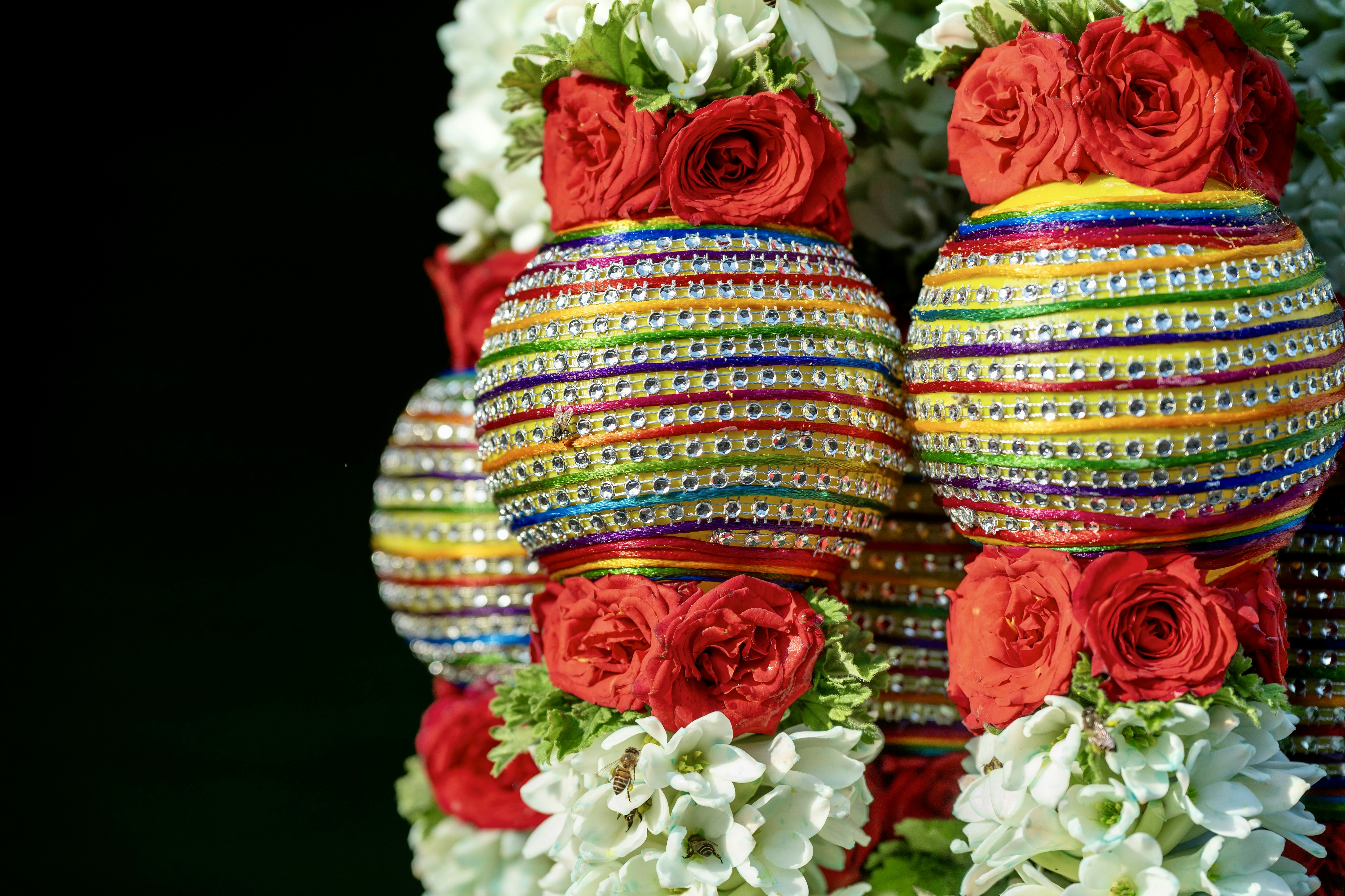 Des pots colorés décorés avec des roses rouges et des fleurs blanches