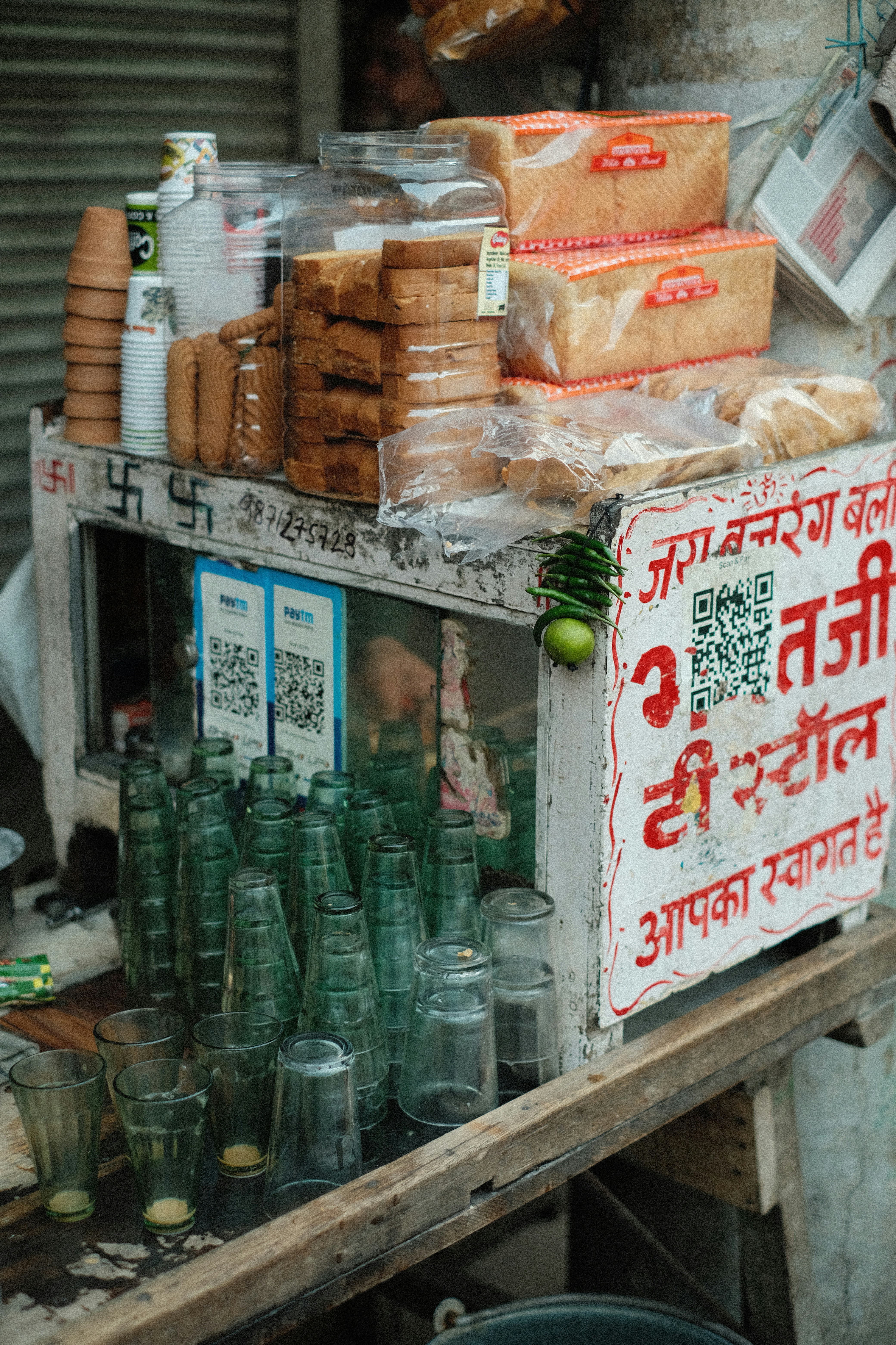 Uma barraca de rua com pão, taças de chá e xícaras.