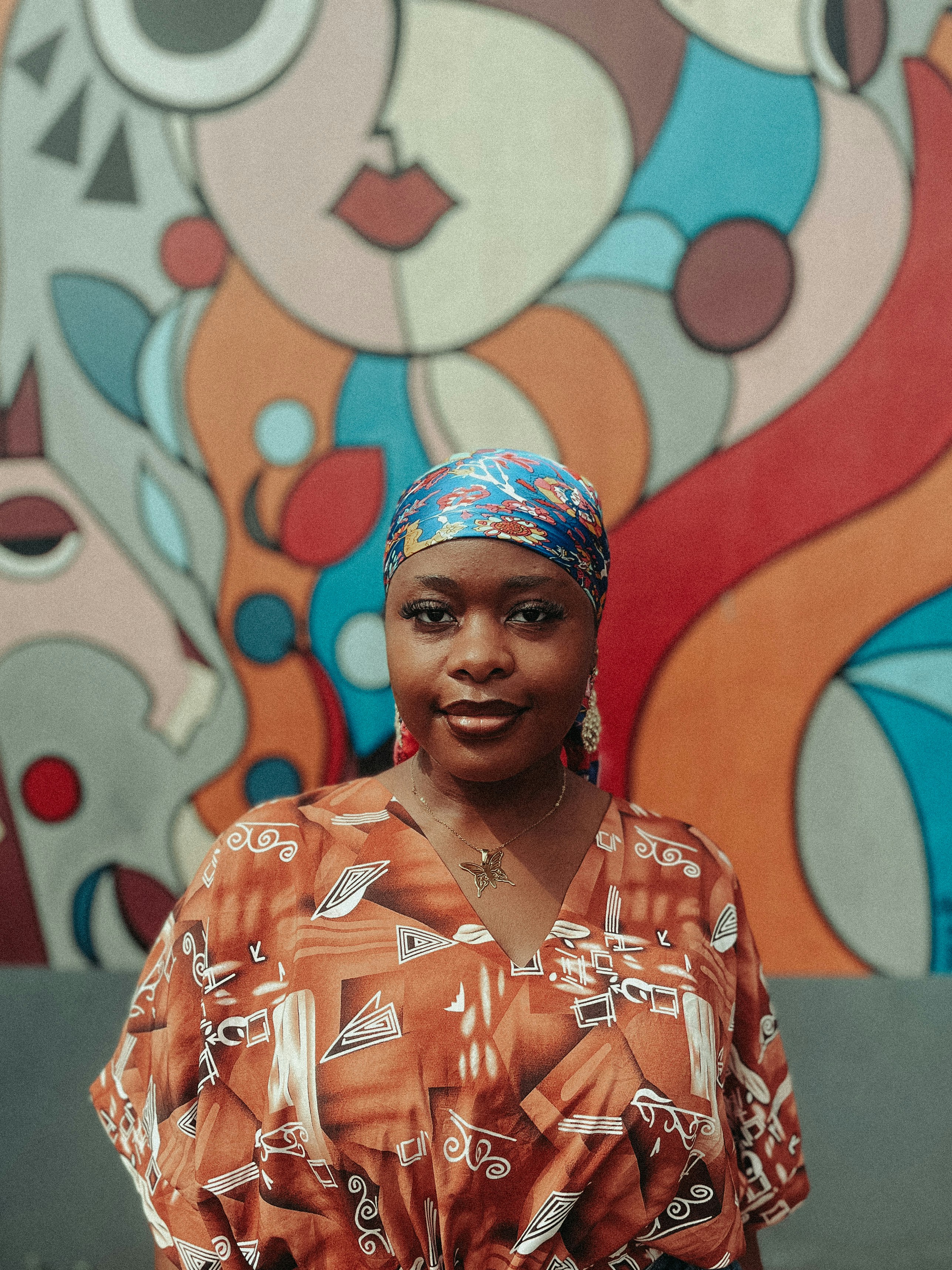 Mulher com lenço colorido e vestido estampado