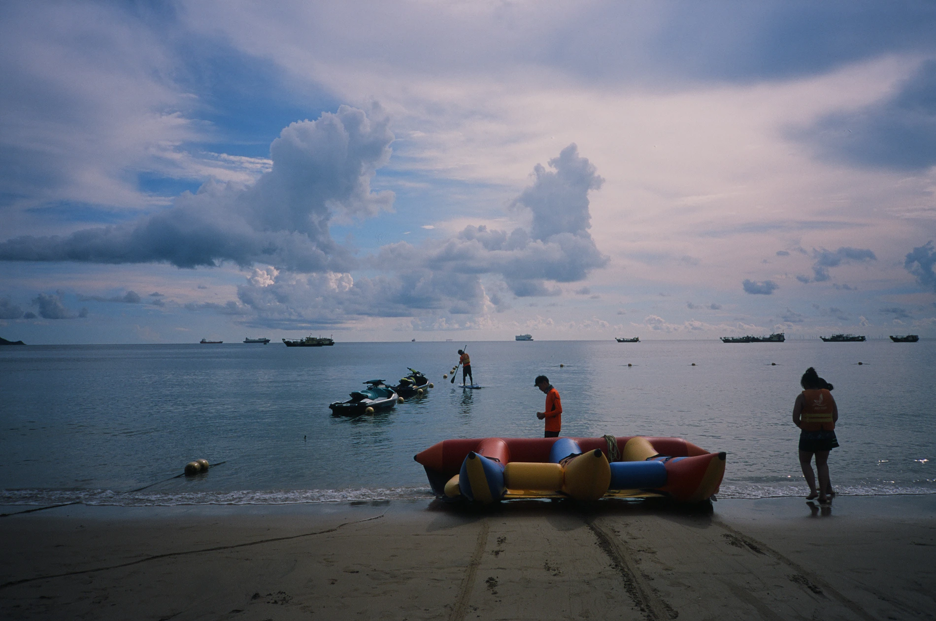 People preparing an inflatable watercraft beside the sea
