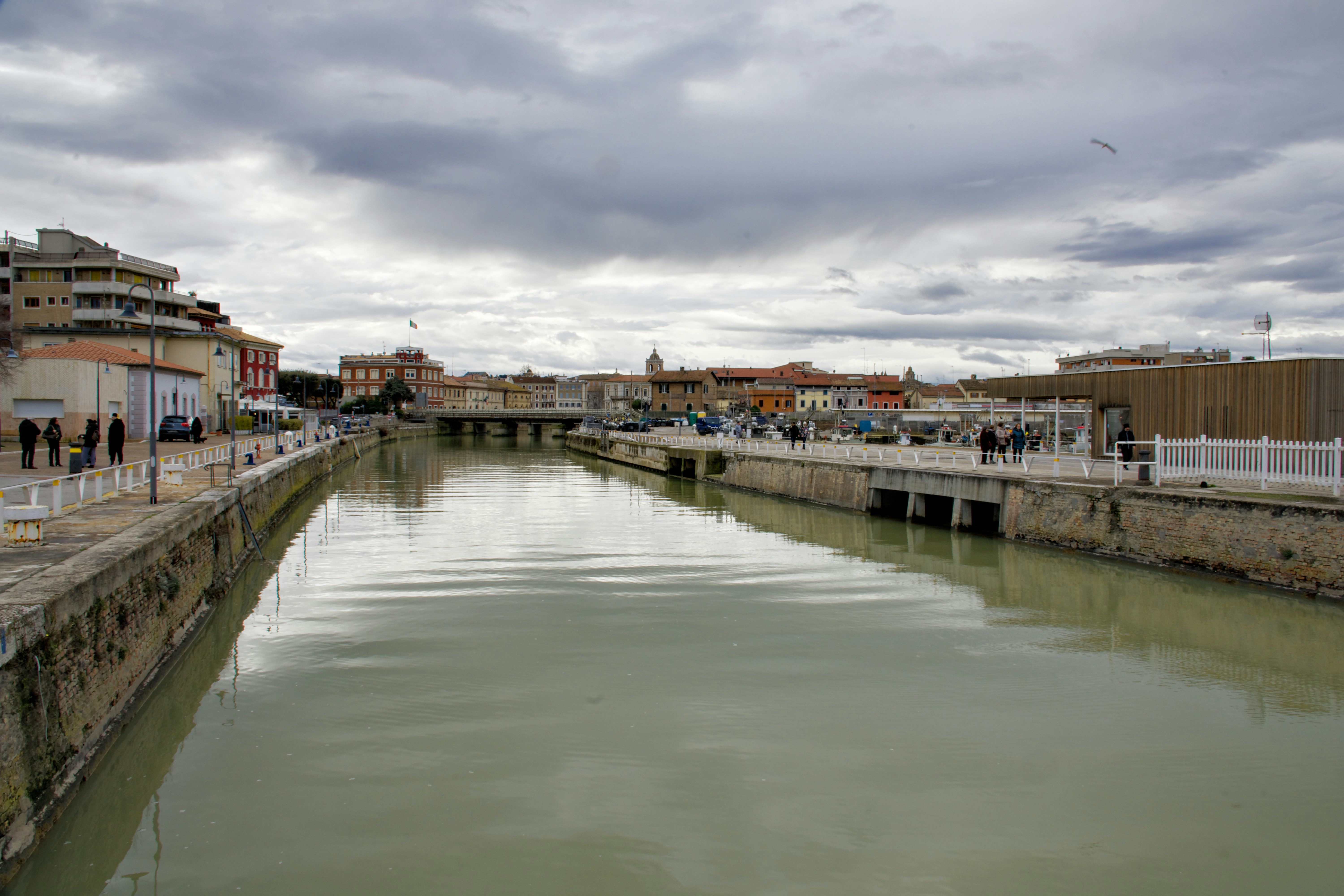Canal with buildings and cloudy sky
