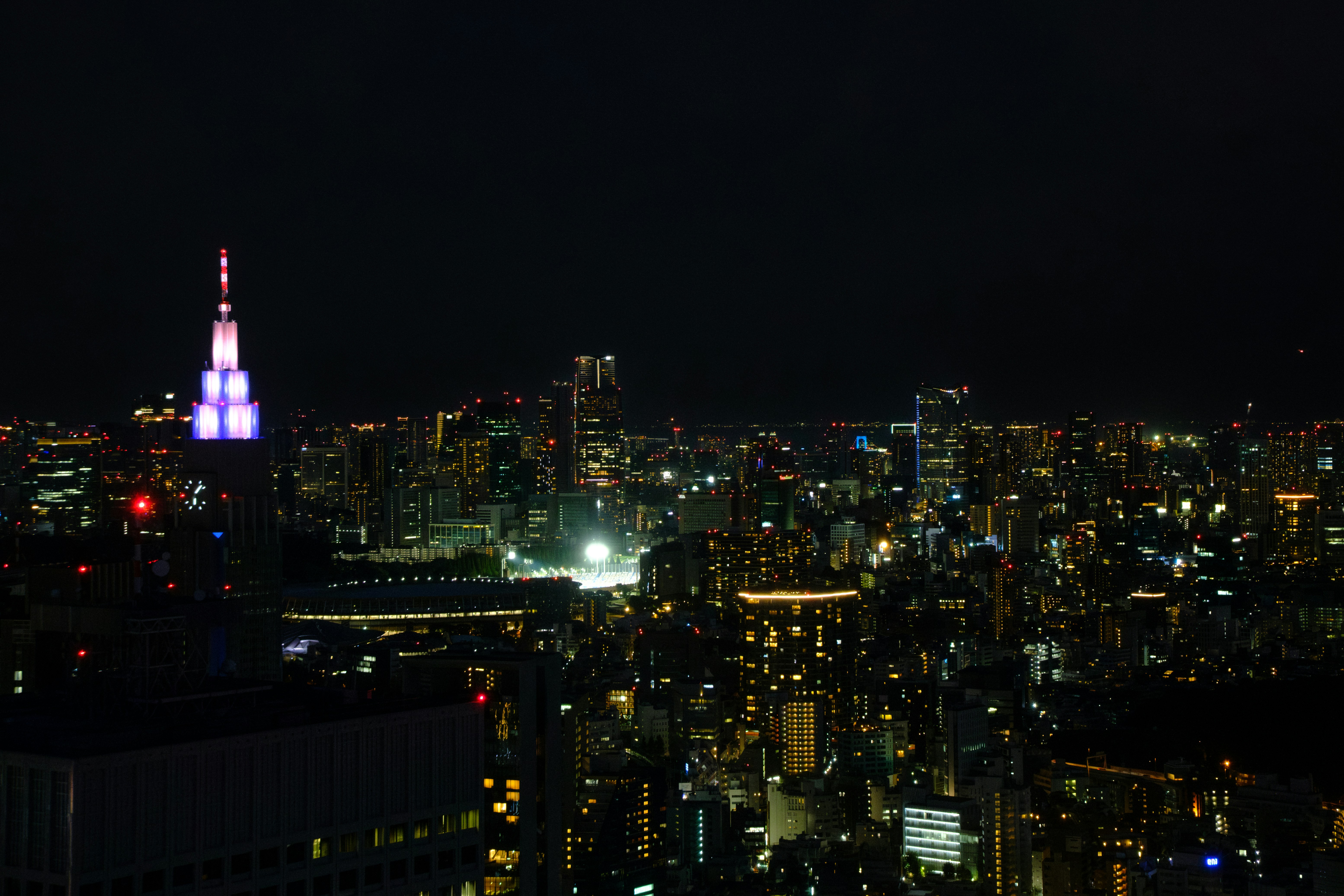 Paysage urbain vibrant la nuit avec des gratte-ciel illuminés