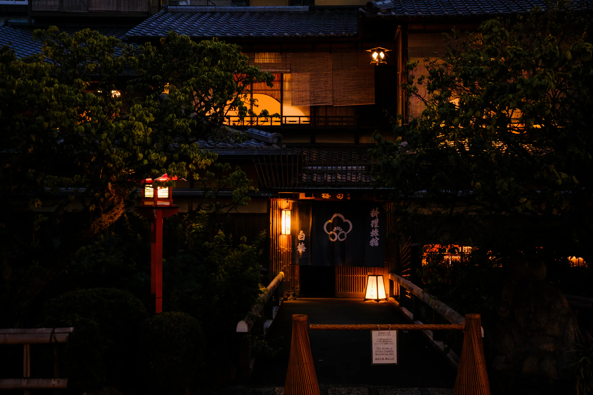 Traditional wooden inn at dusk with glowing lanterns and lit windows