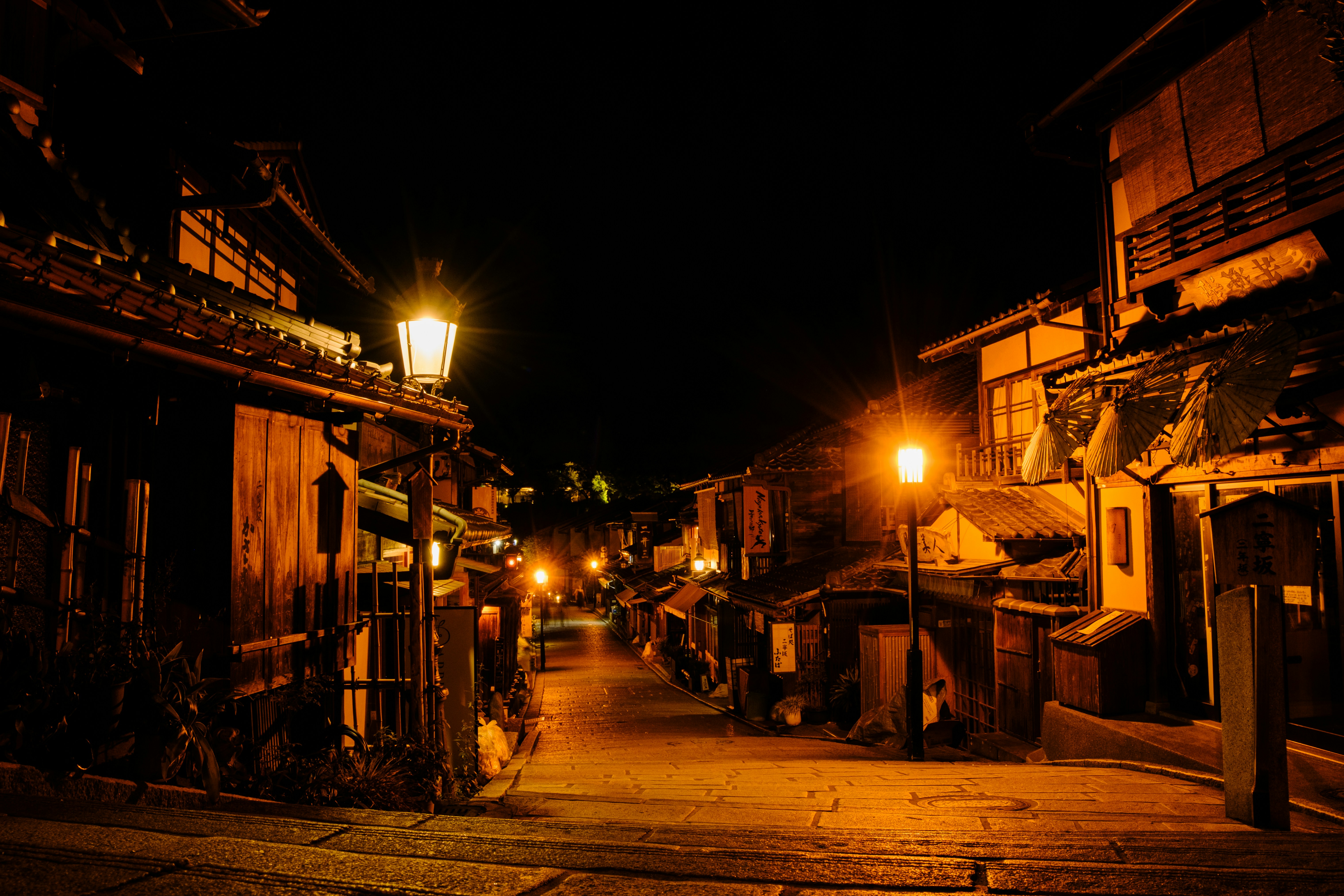 Une rue historique éclairée par des lanternes la nuit.