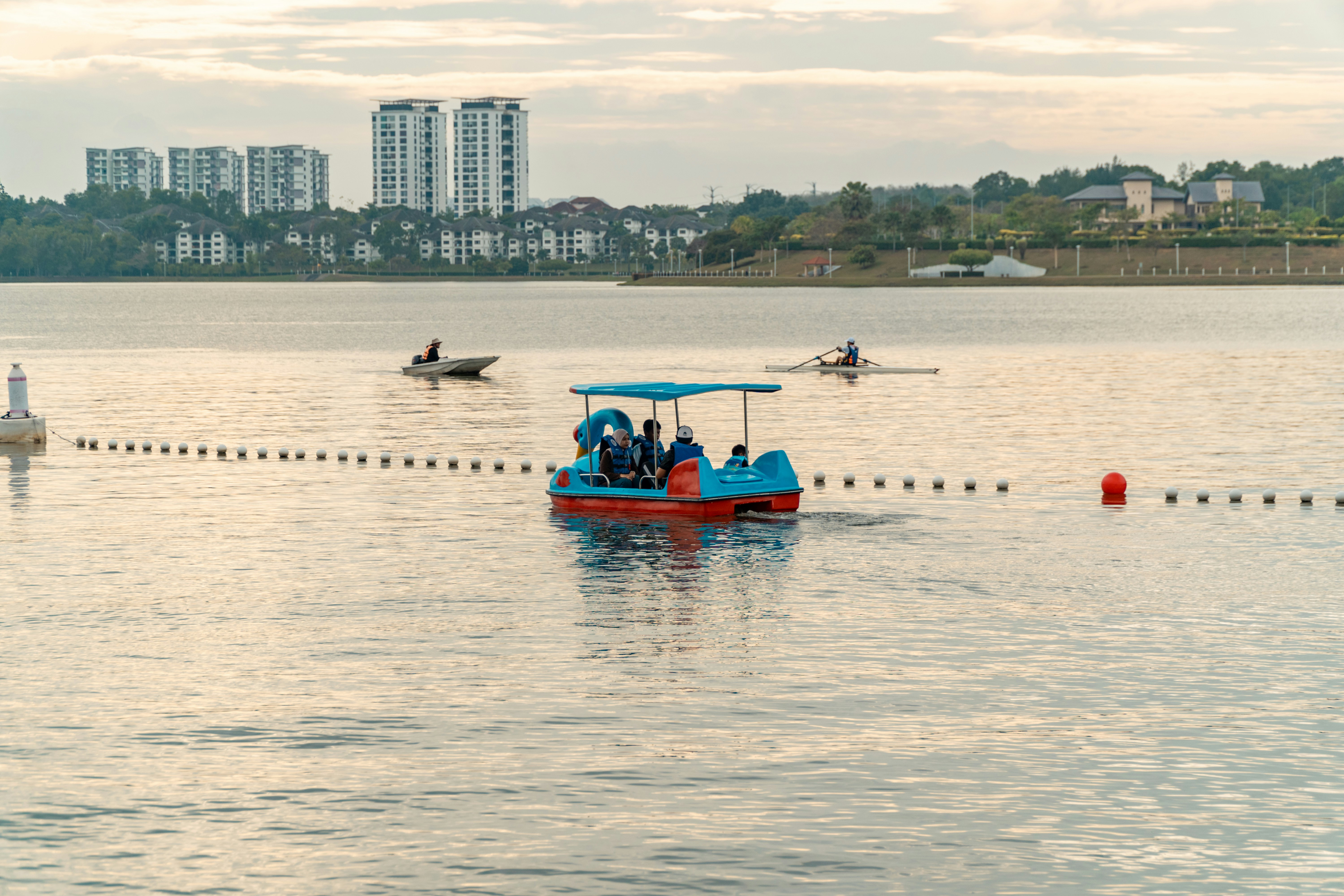 People enjoy a paddle boat ride on a calm lake.