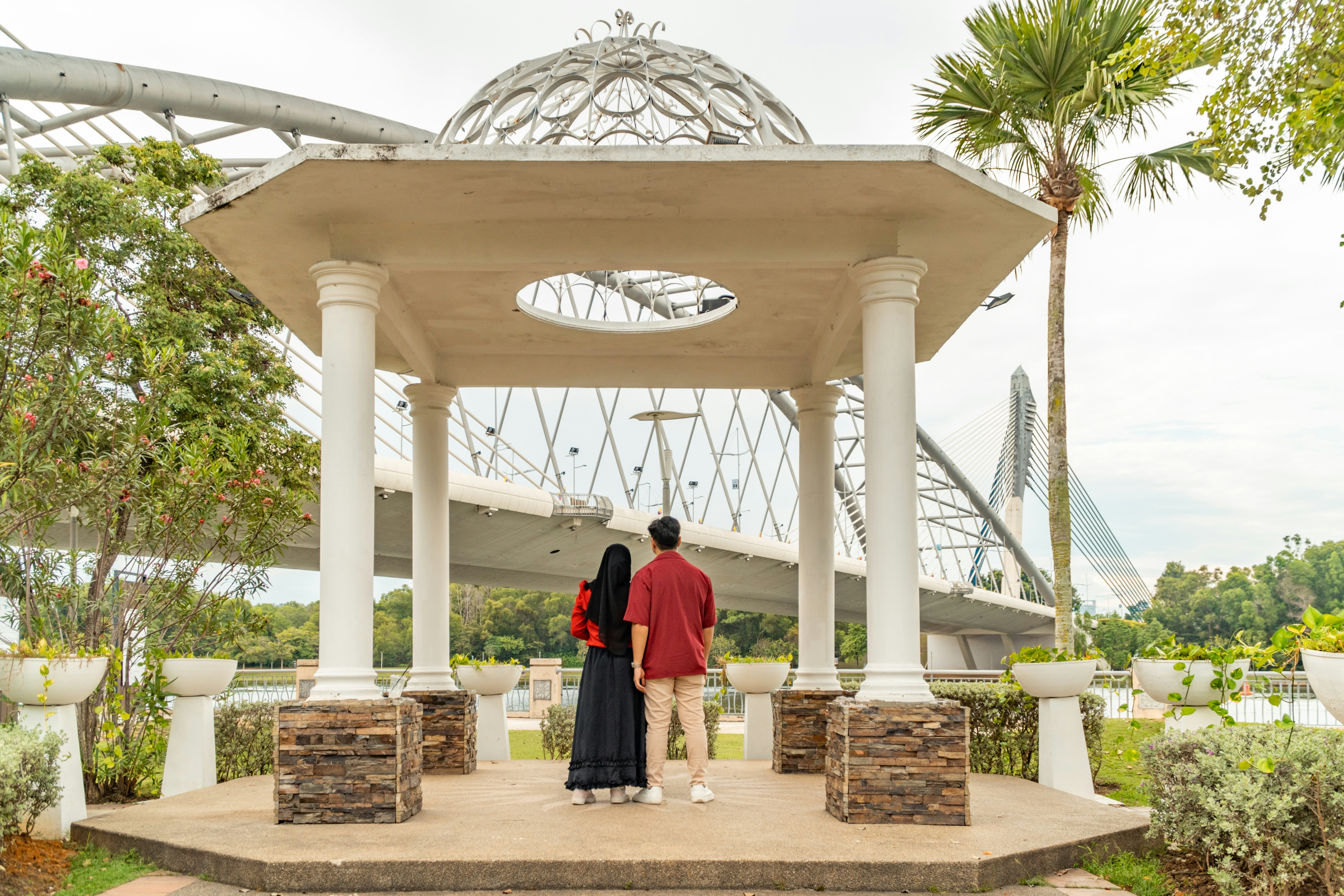 Couple standing under a gazebo overlooking a bridge