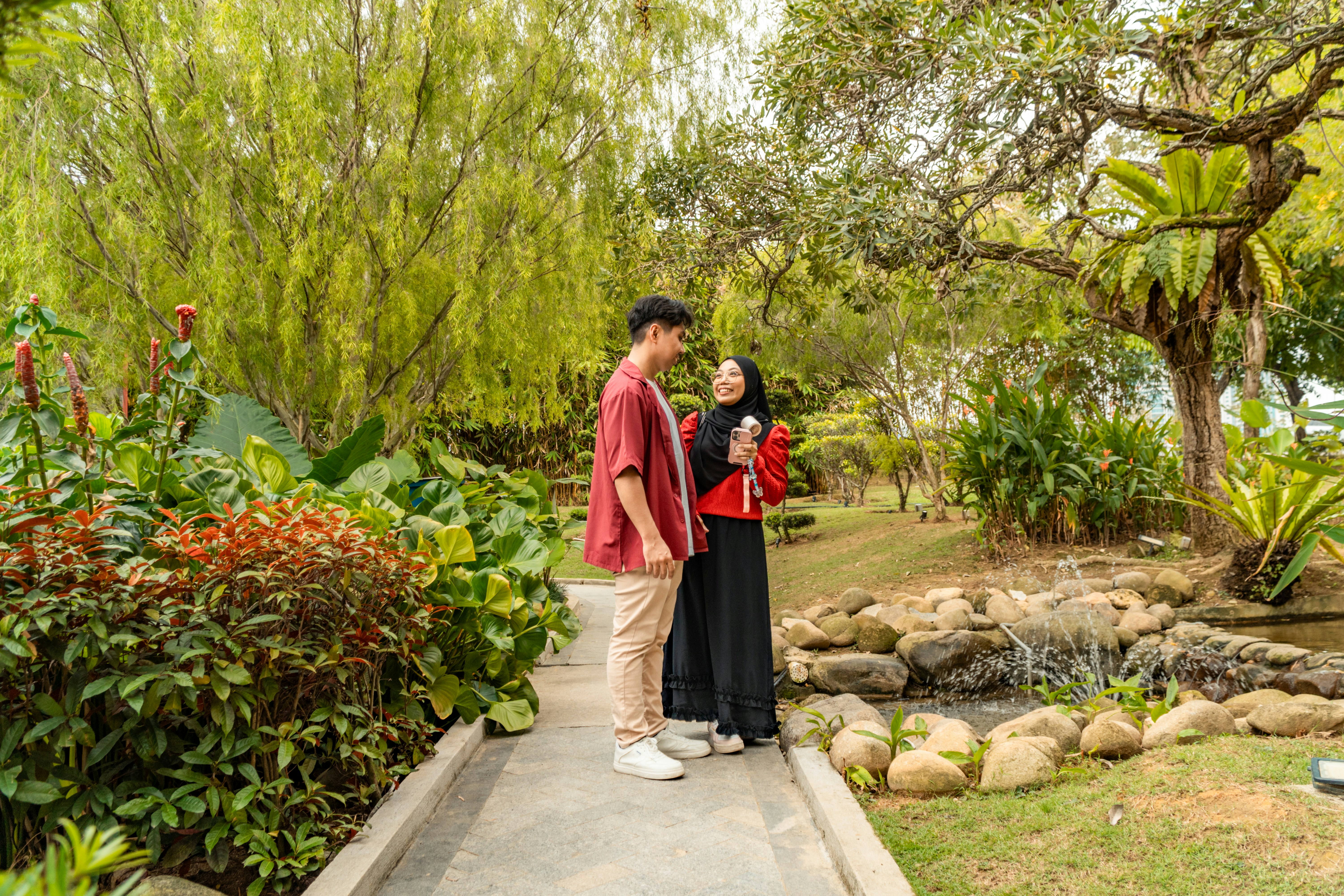 Couple standing on a path in a lush garden