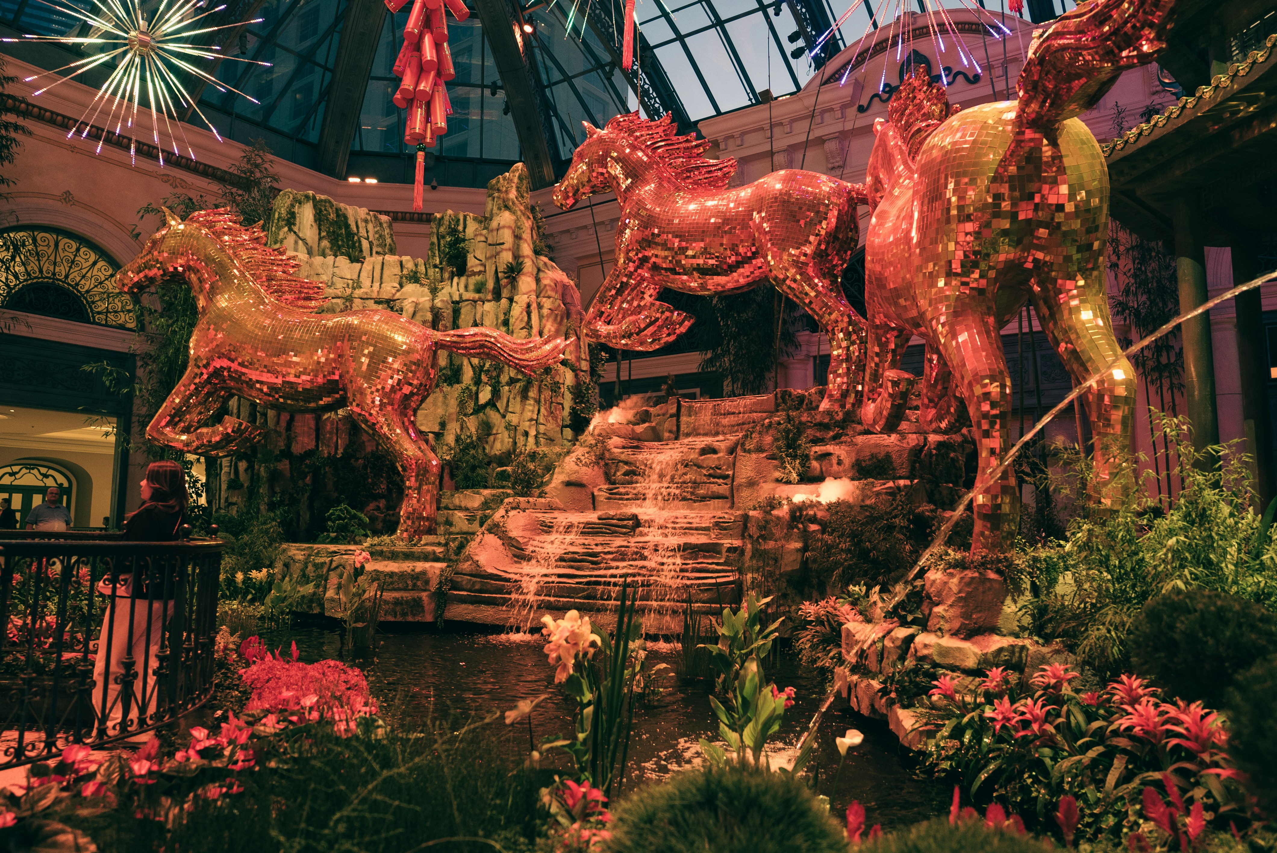 Golden horse sculptures in a lush garden setting.