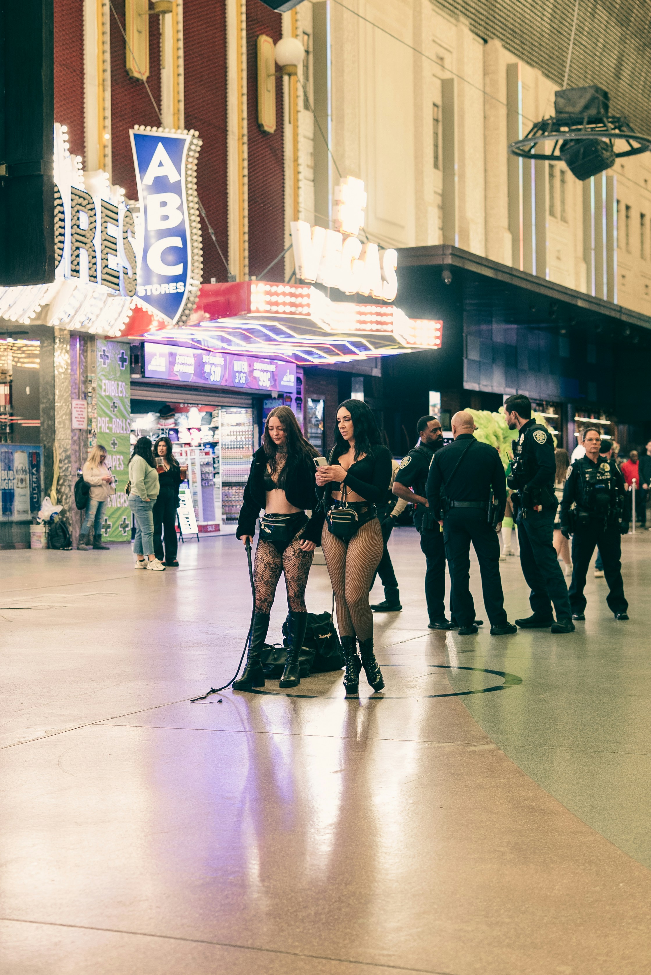 Two women in revealing outfits stand on a street.