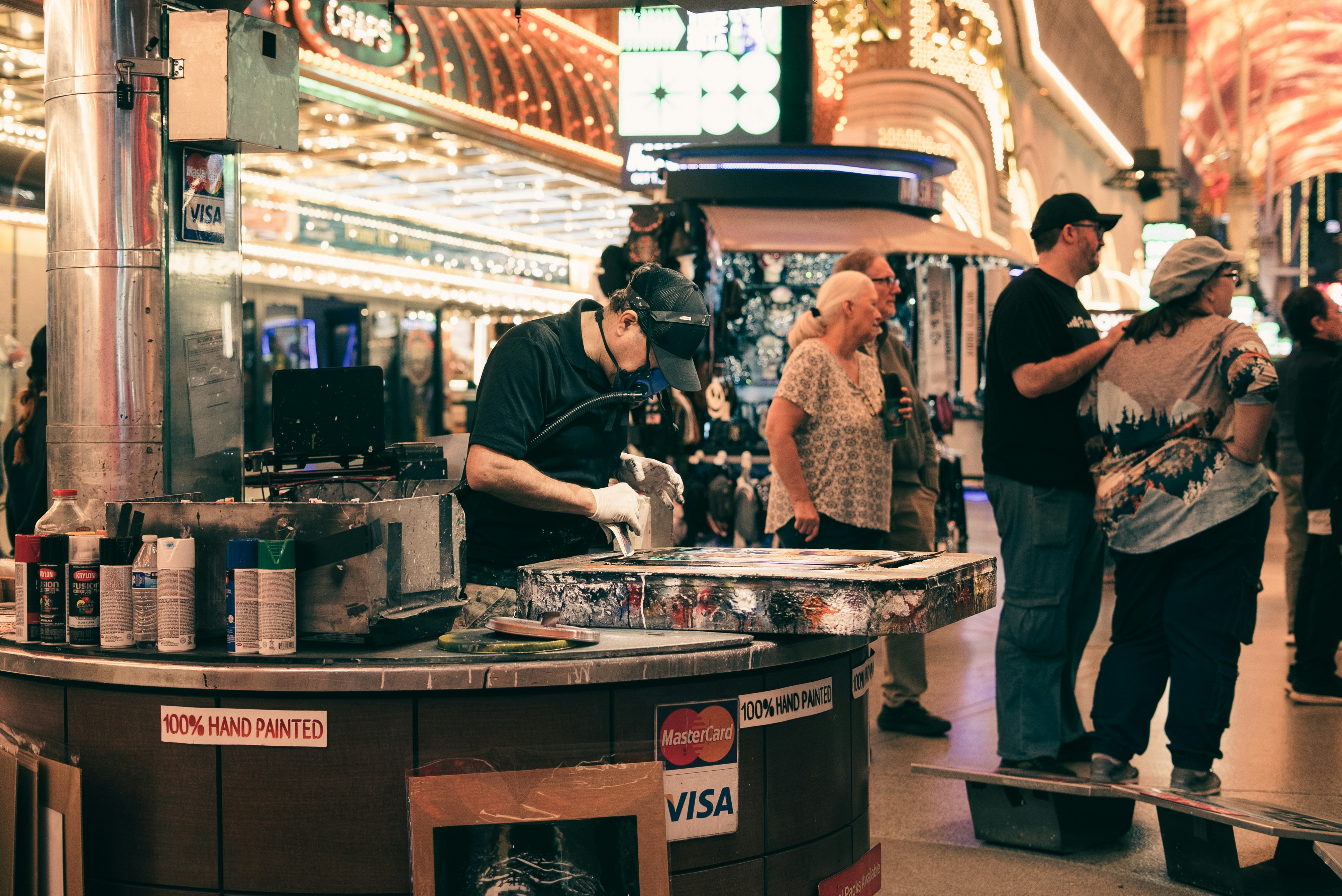 People watch a vendor prepare food at a street stall.