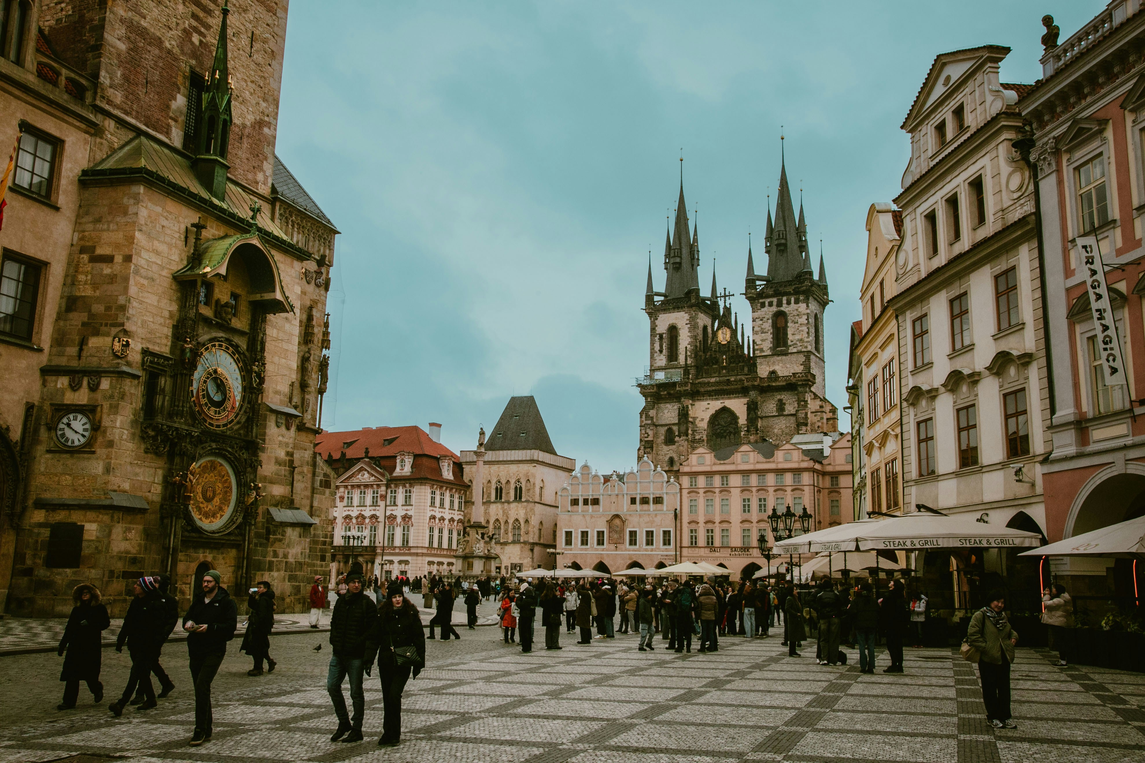 People walking in a european city square with historic buildings.