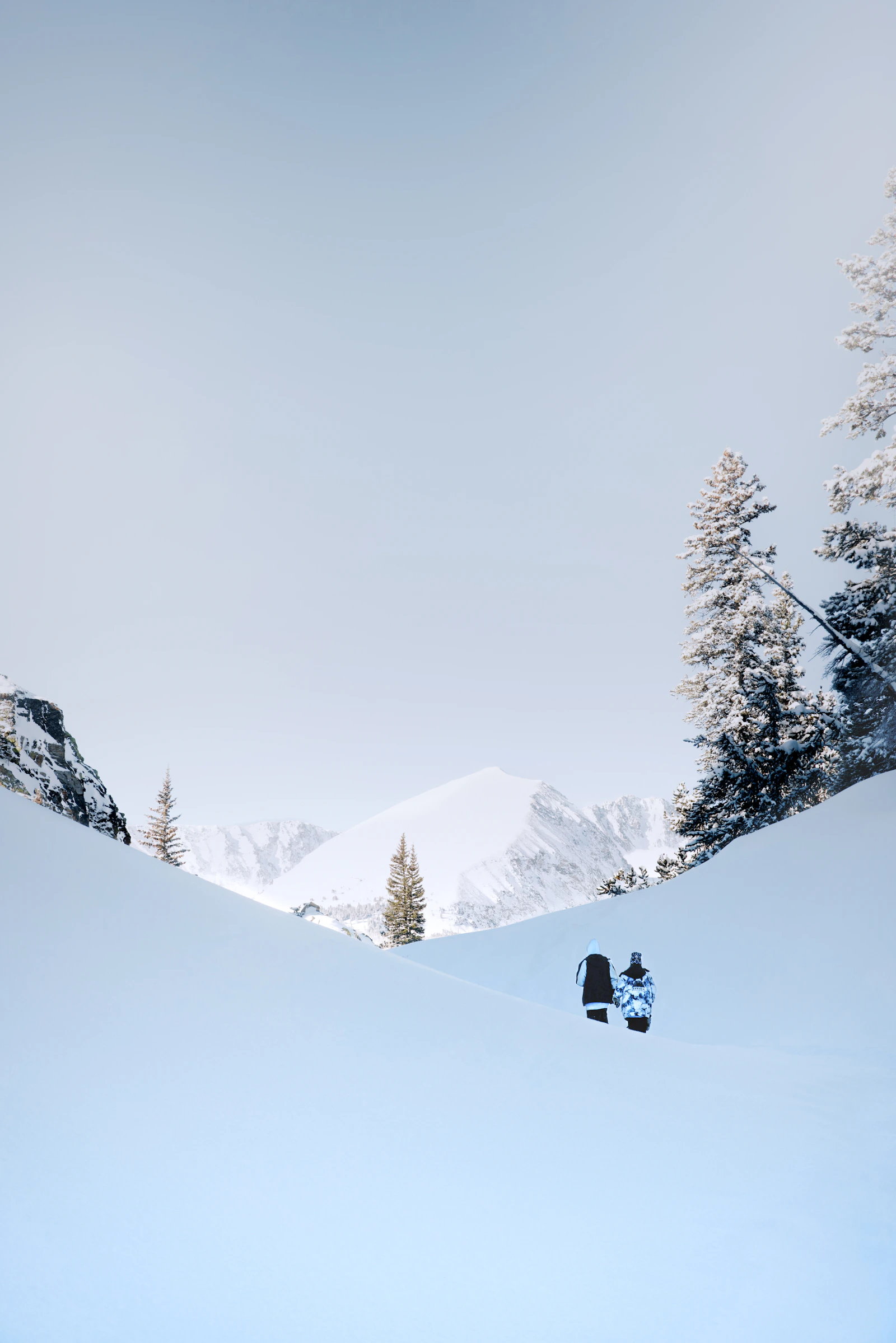 A person walks on a path through deep snow.