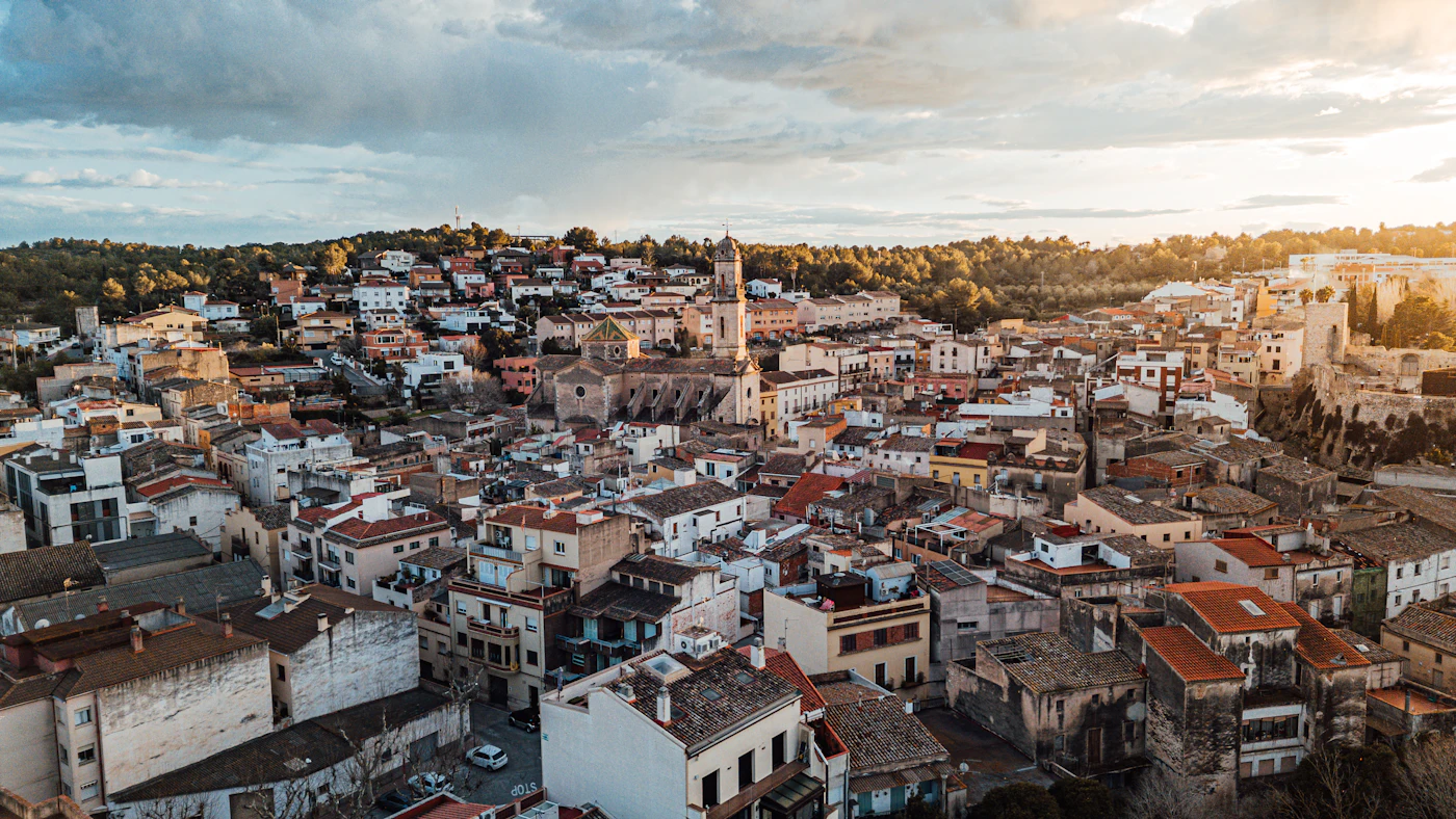 Blick über die Dächer von Stone Town mit einem Dhau-Segelboot bei Sonnenuntergang