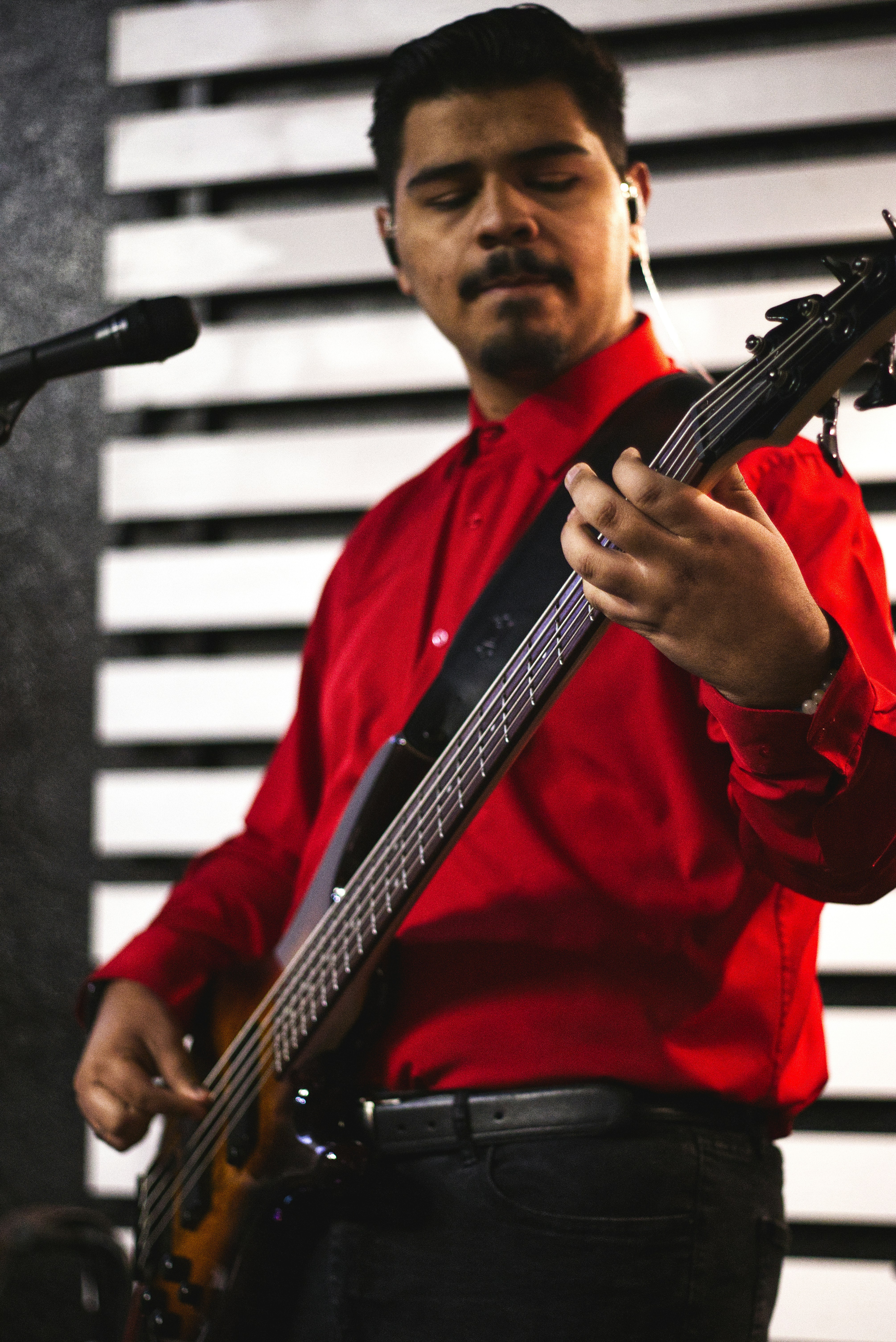 Homem tocando um baixo vermelho no palco