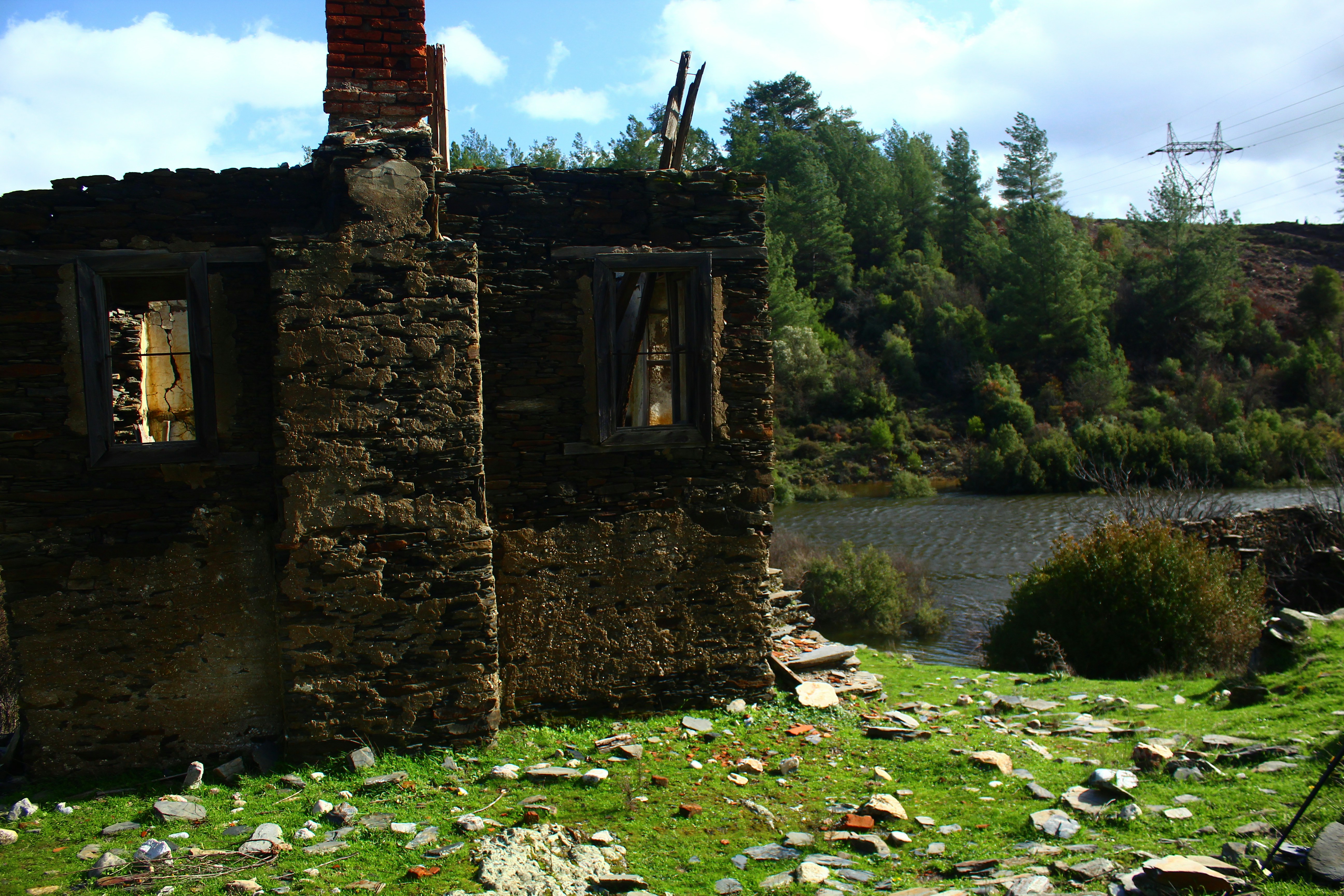 湖のそばに木々が生えた廃墟の石造建築