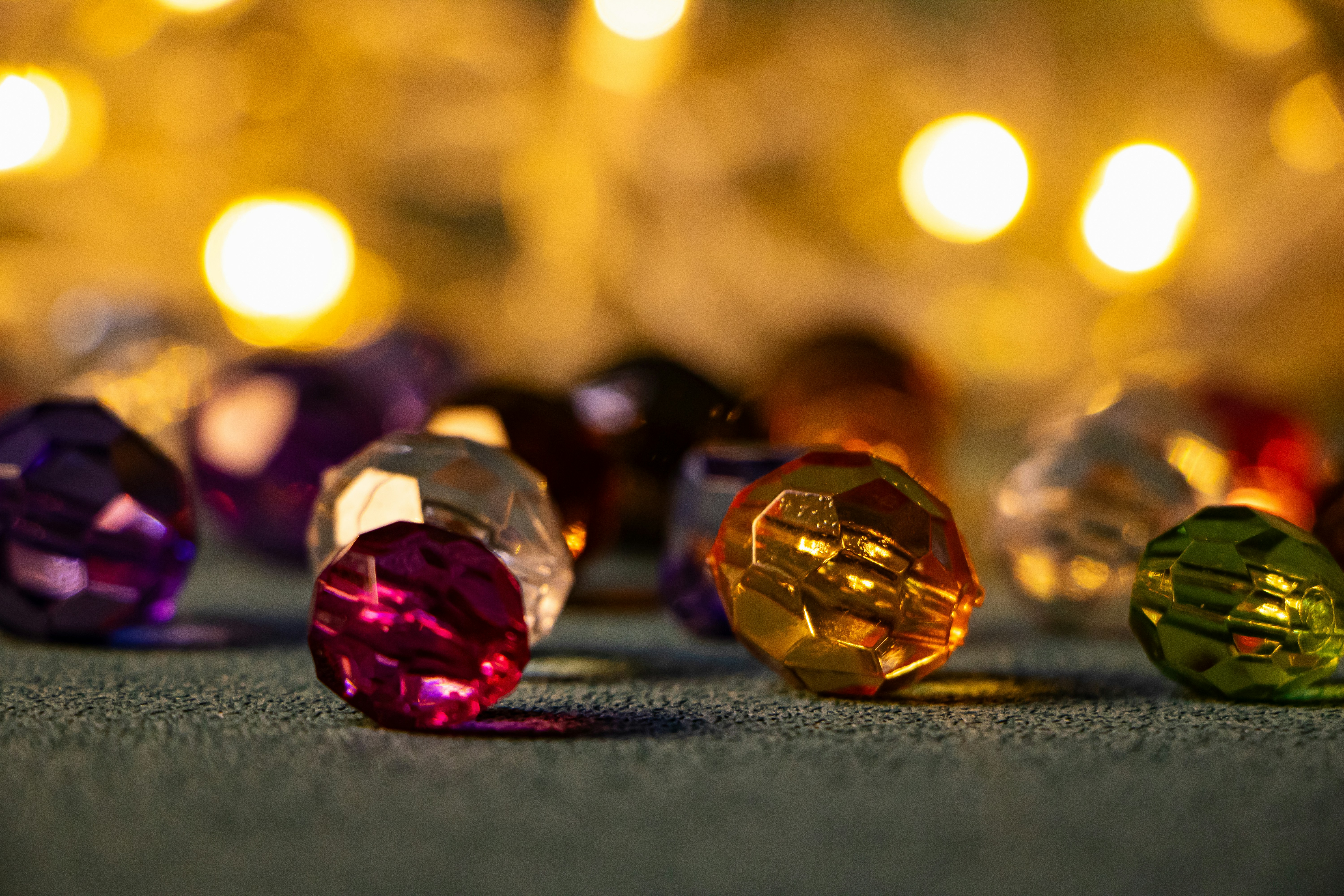 Colorful faceted beads with bokeh lights in background