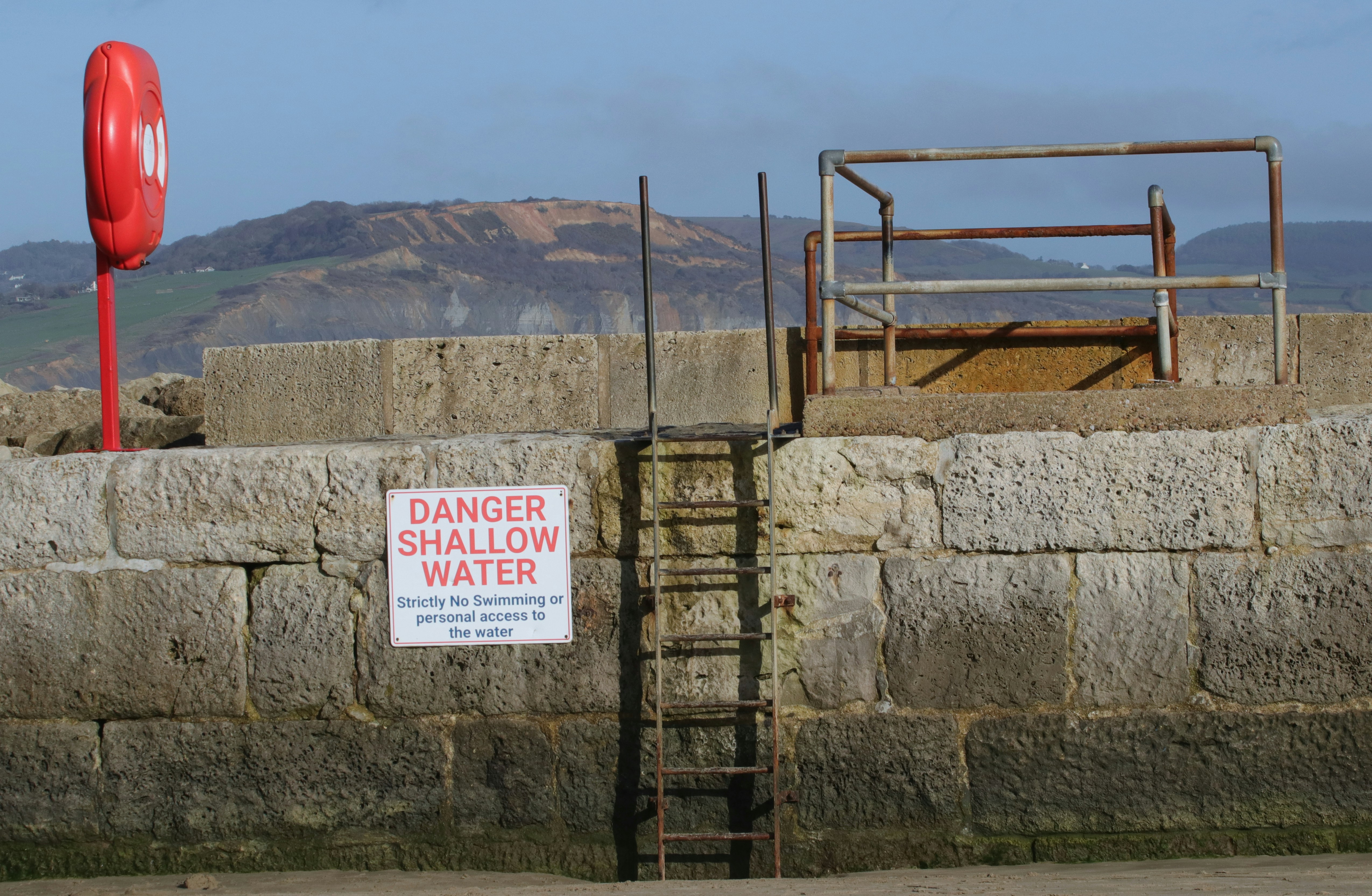 Danger shallow water sign on a concrete wall