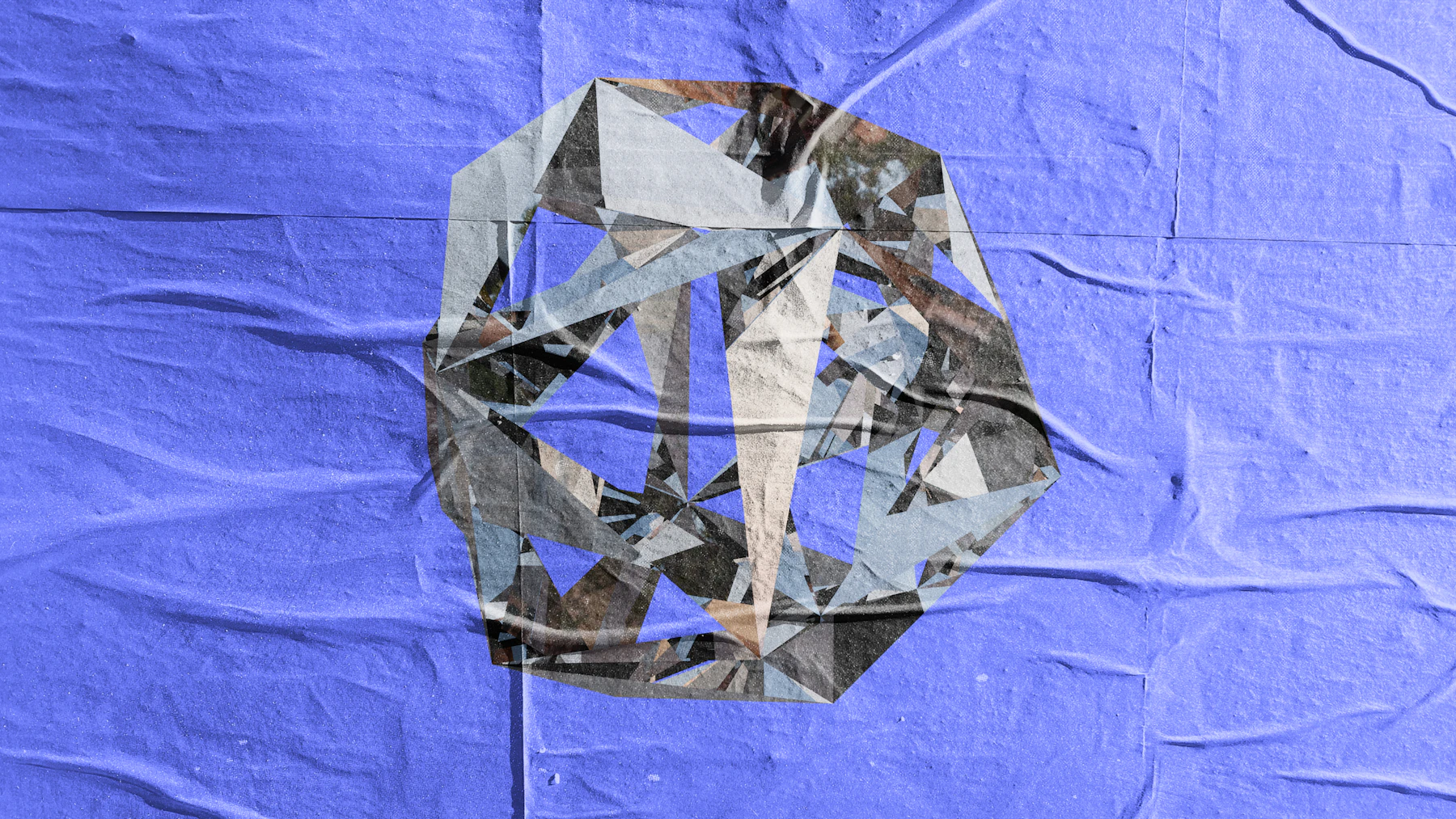 Abstract geometric form over crumpled blue paper