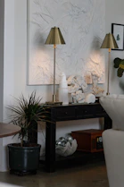Two brass lamps on a black console table.