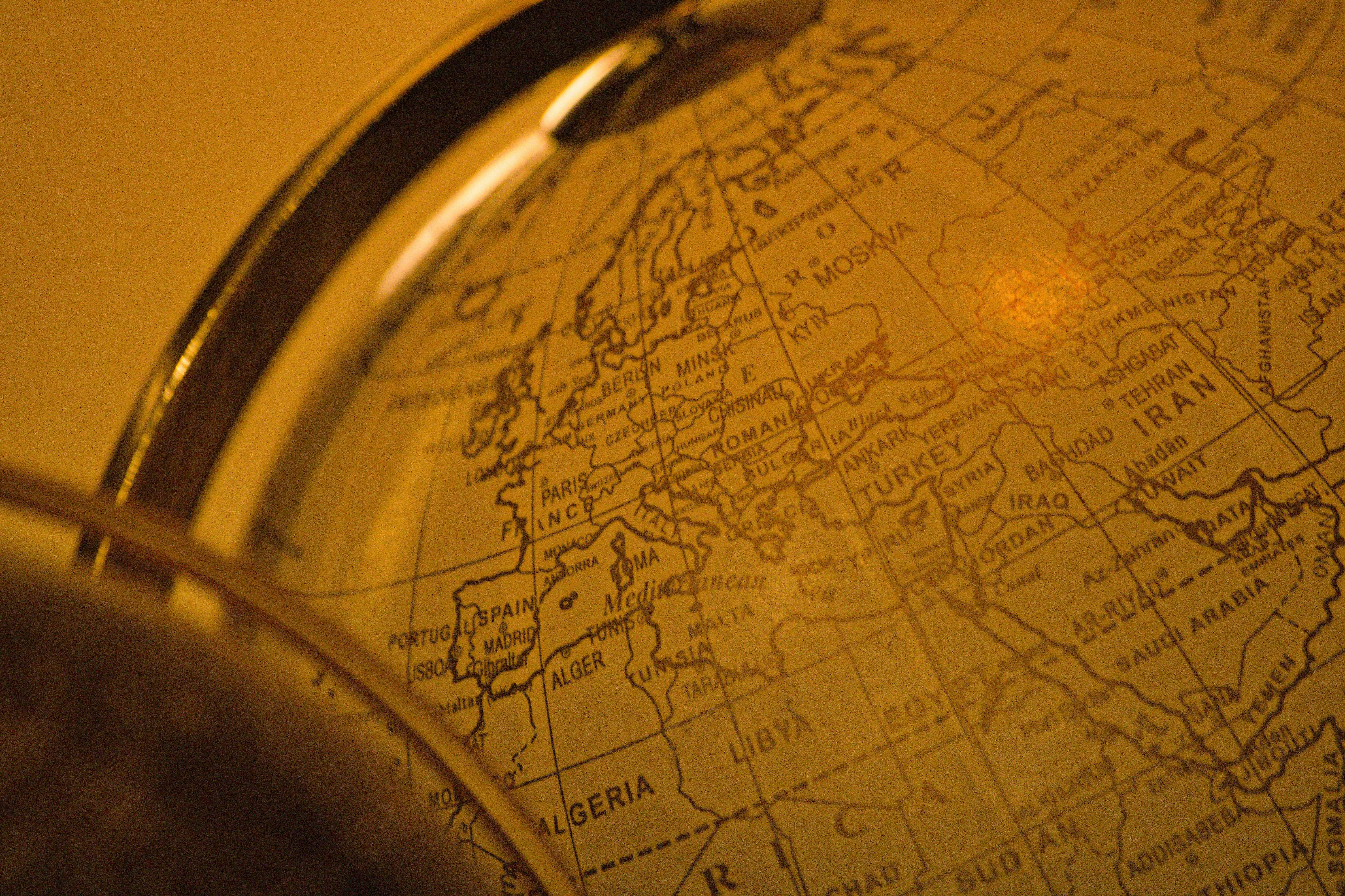 A passenger looking stressed while talking on a phone at an airport, with a canceled flight status on a large screen in the background, showing the personal impact.
