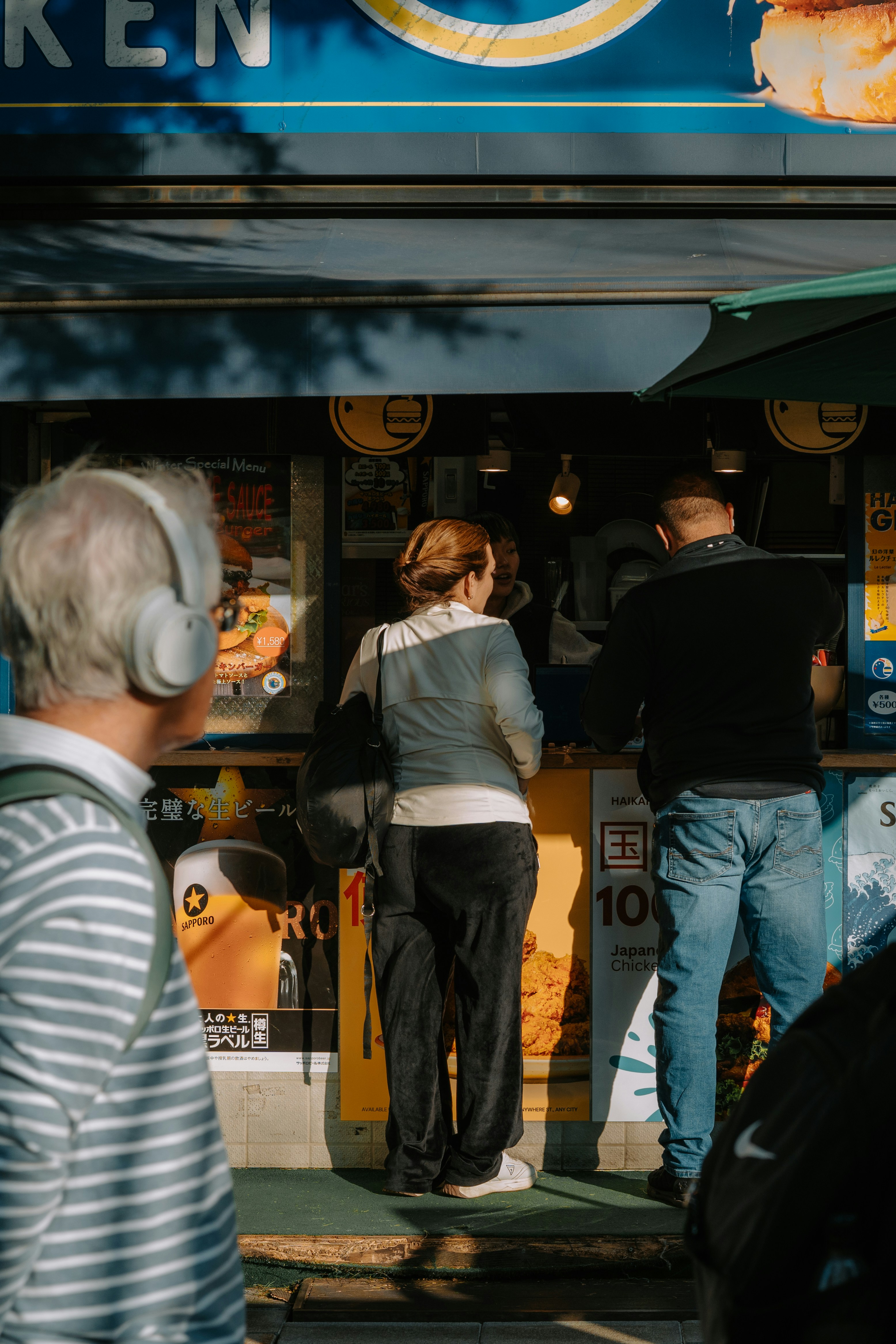 People ordering food at a street vendor stand.