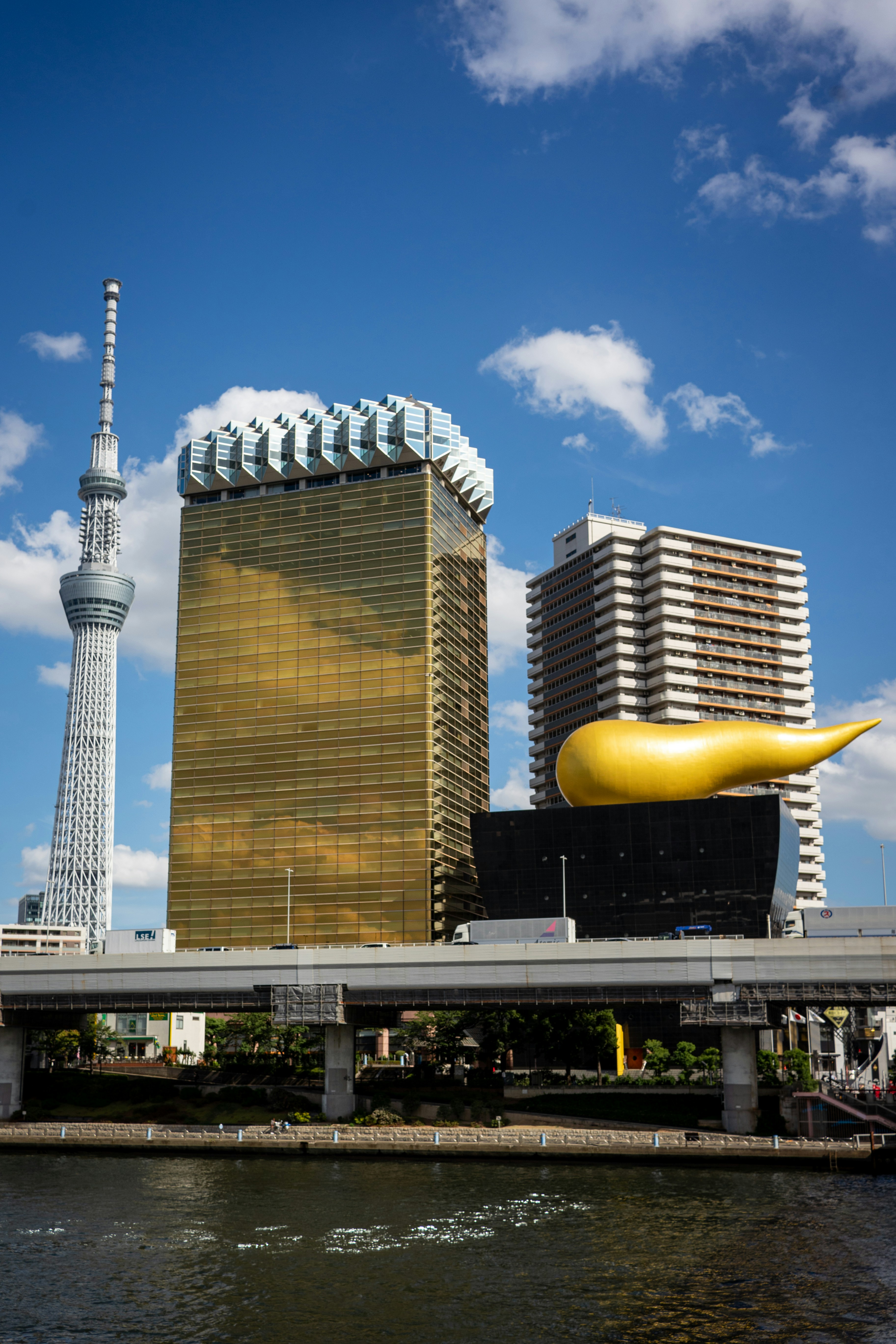 Modern skyscrapers and a bridge over a river.
