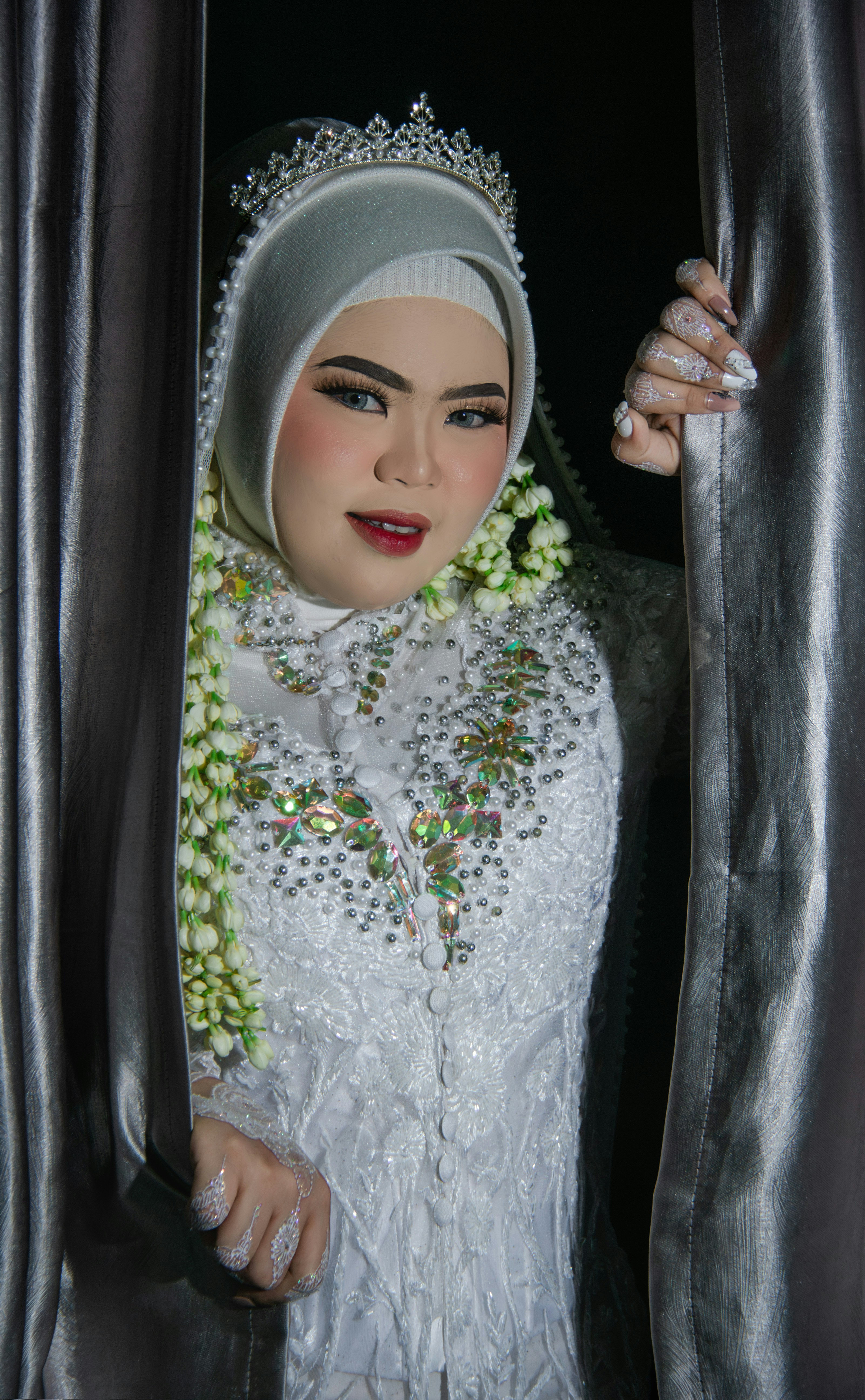 Pengantin wanita dengan gaun putih dan jilbab mengintip melalui tirai
