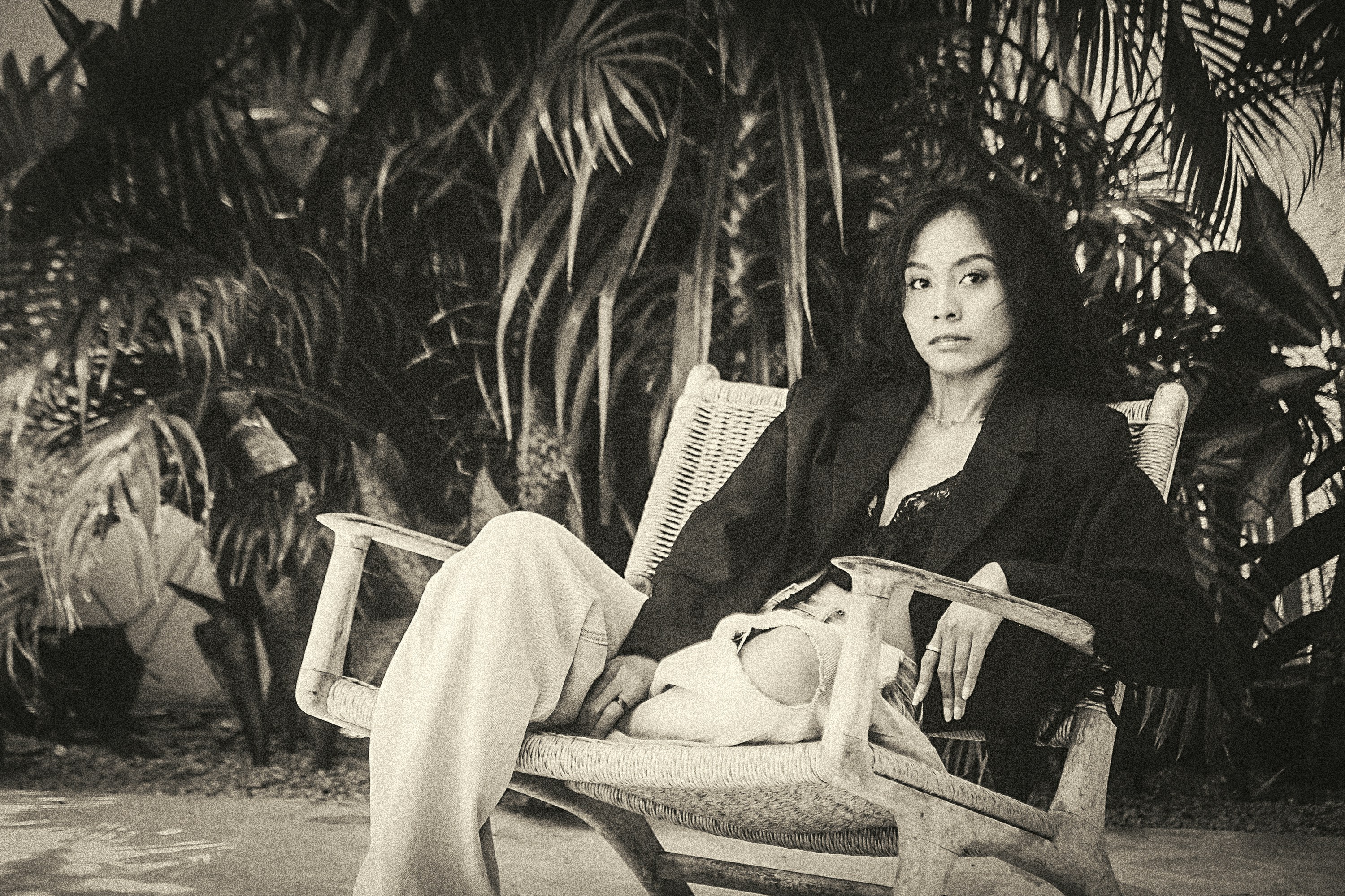 Woman sitting on a lounge chair surrounded by plants