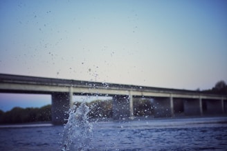 Water splashing in front of a bridge over a river