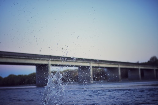 Water splashing in front of a bridge over a river