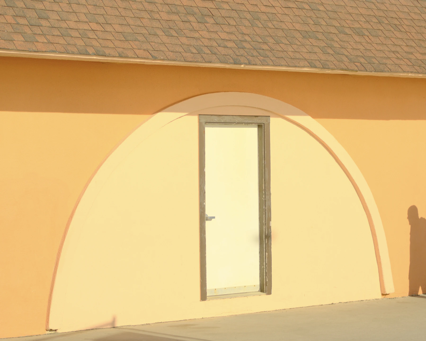 Warm orange architectural archway with sunlight and shadow