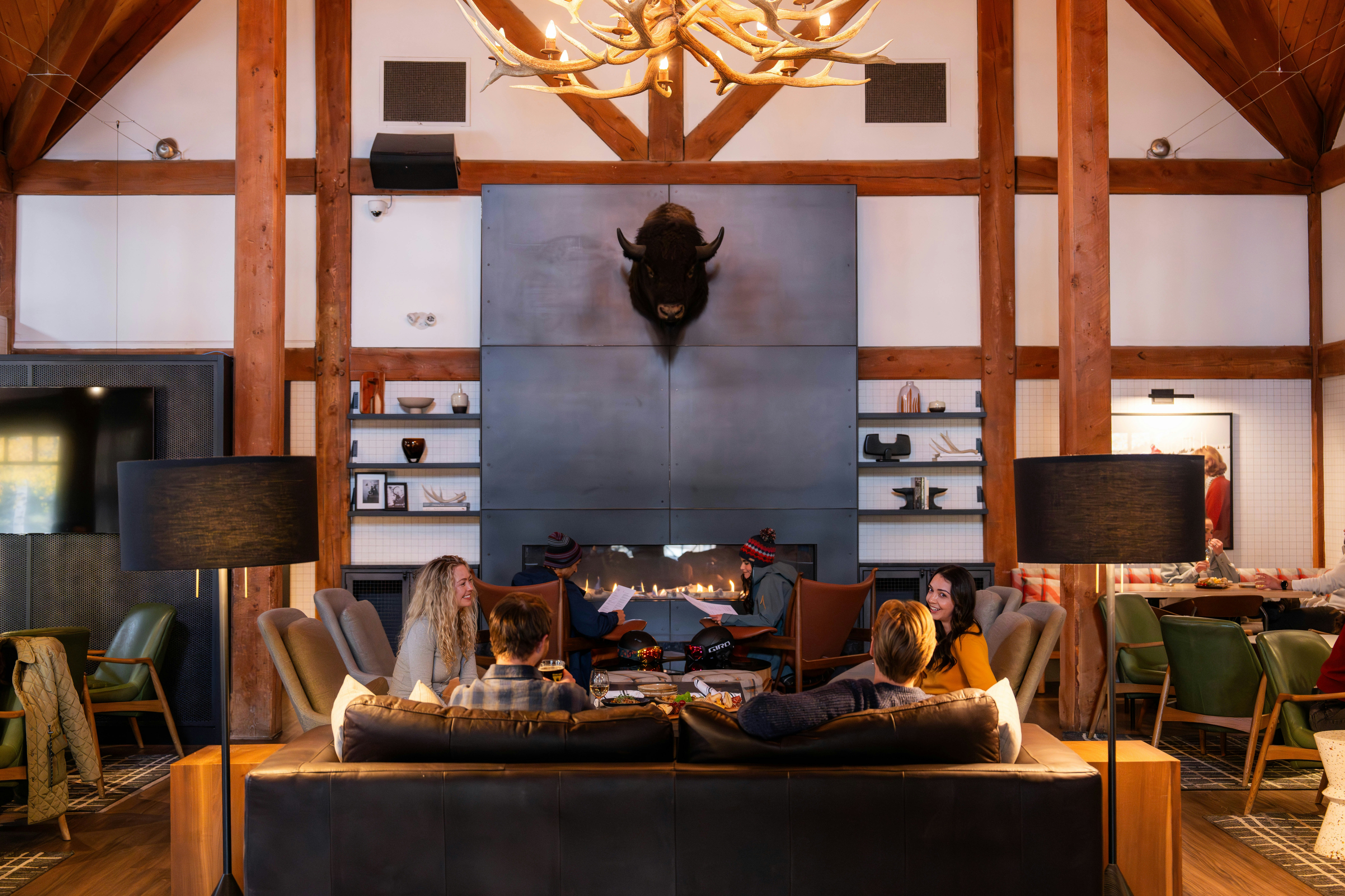 People relax in a cozy lodge with a large fireplace.