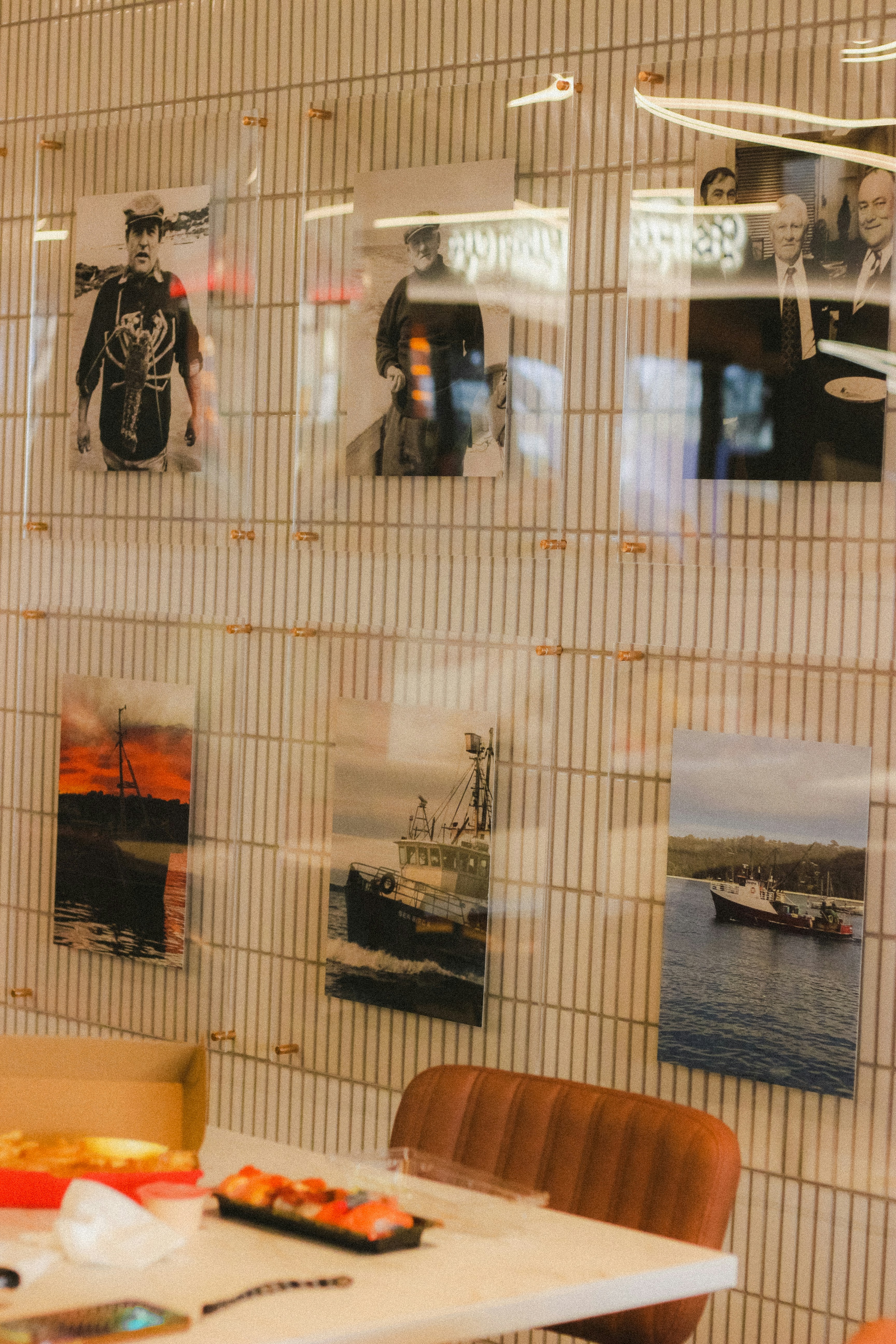 Framed historical photographs and seafaring scenes displayed