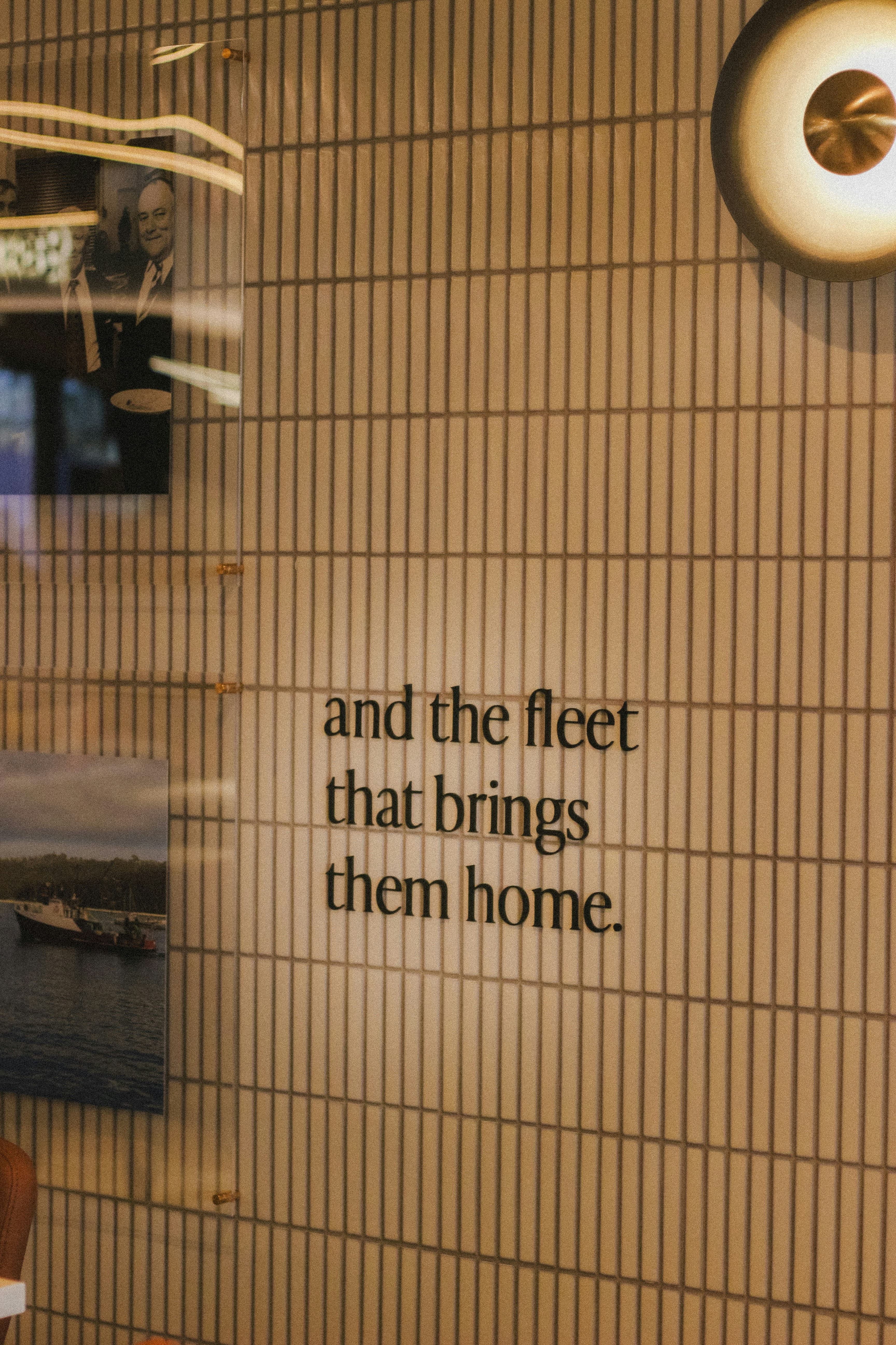 Text on a tiled wall with framed pictures.