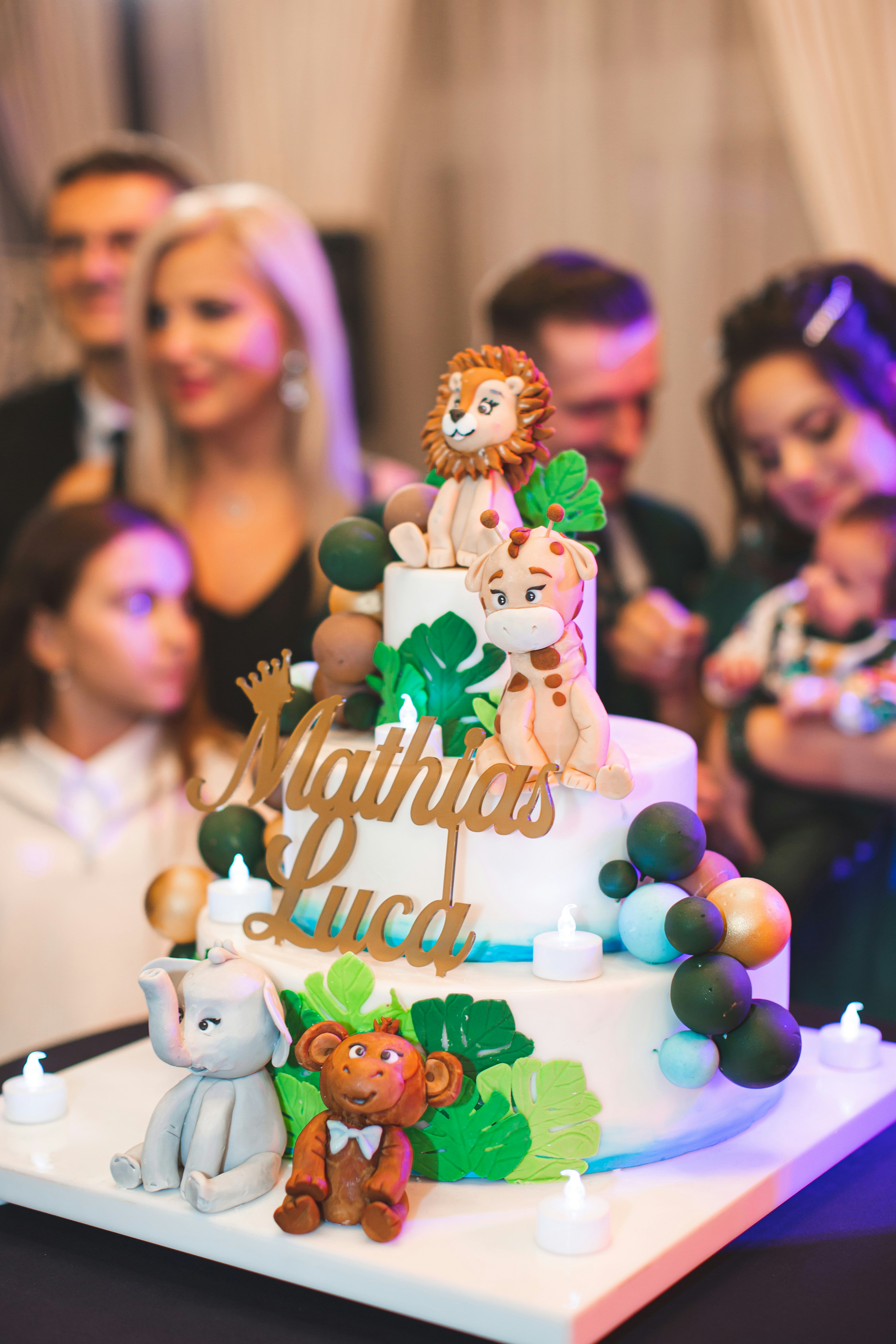 Una tarta de cumpleaños temática de la selva con decoraciones de animales.