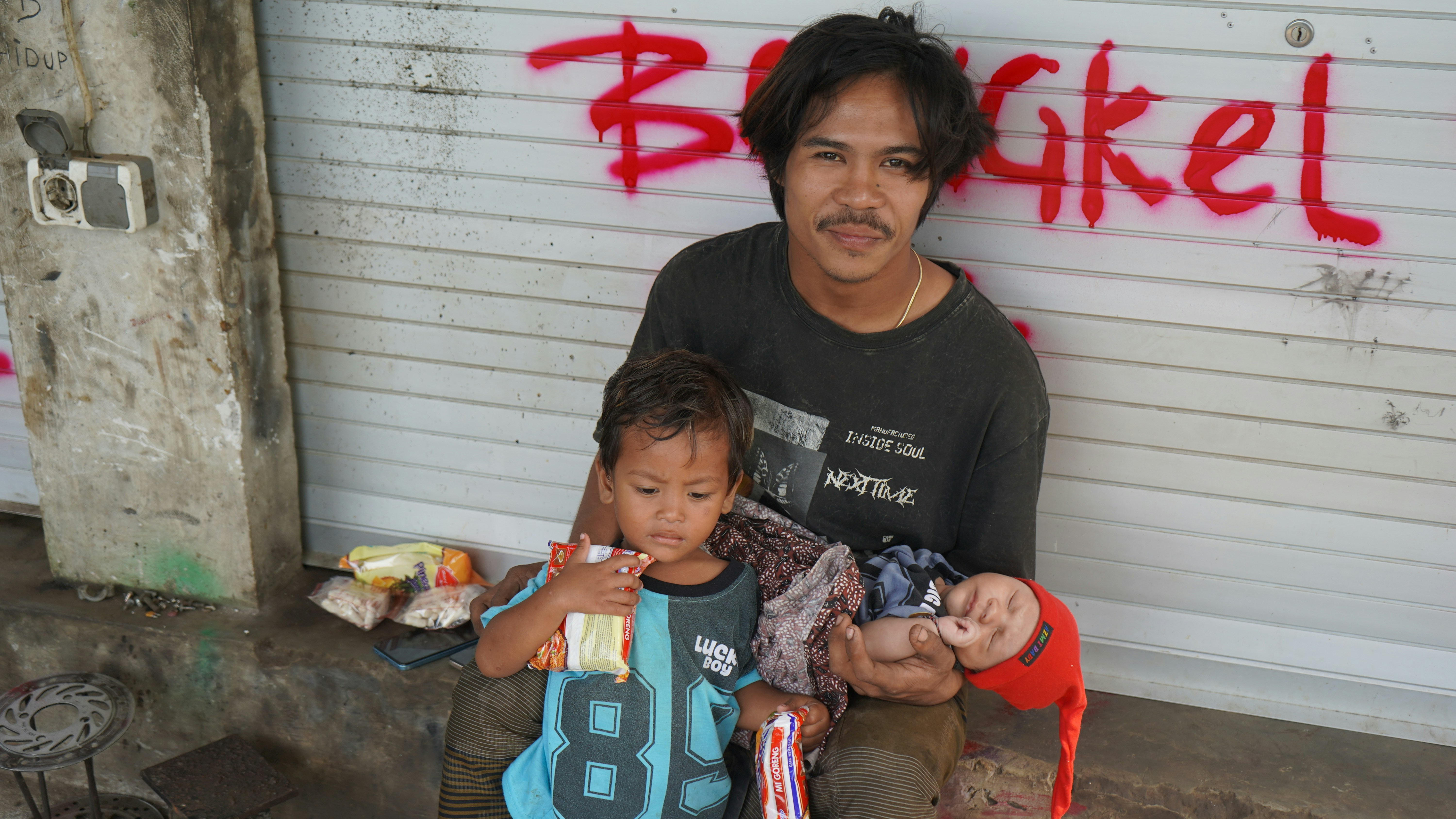 Man with two children sitting outside